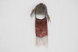 Red Coral & Wool Adornment hanging on a small oak frame on a white wall