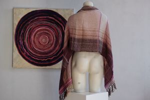 Handwoven scarf naturally dyed shades of pink and fuchsia on a white mannequin in a white gallery space