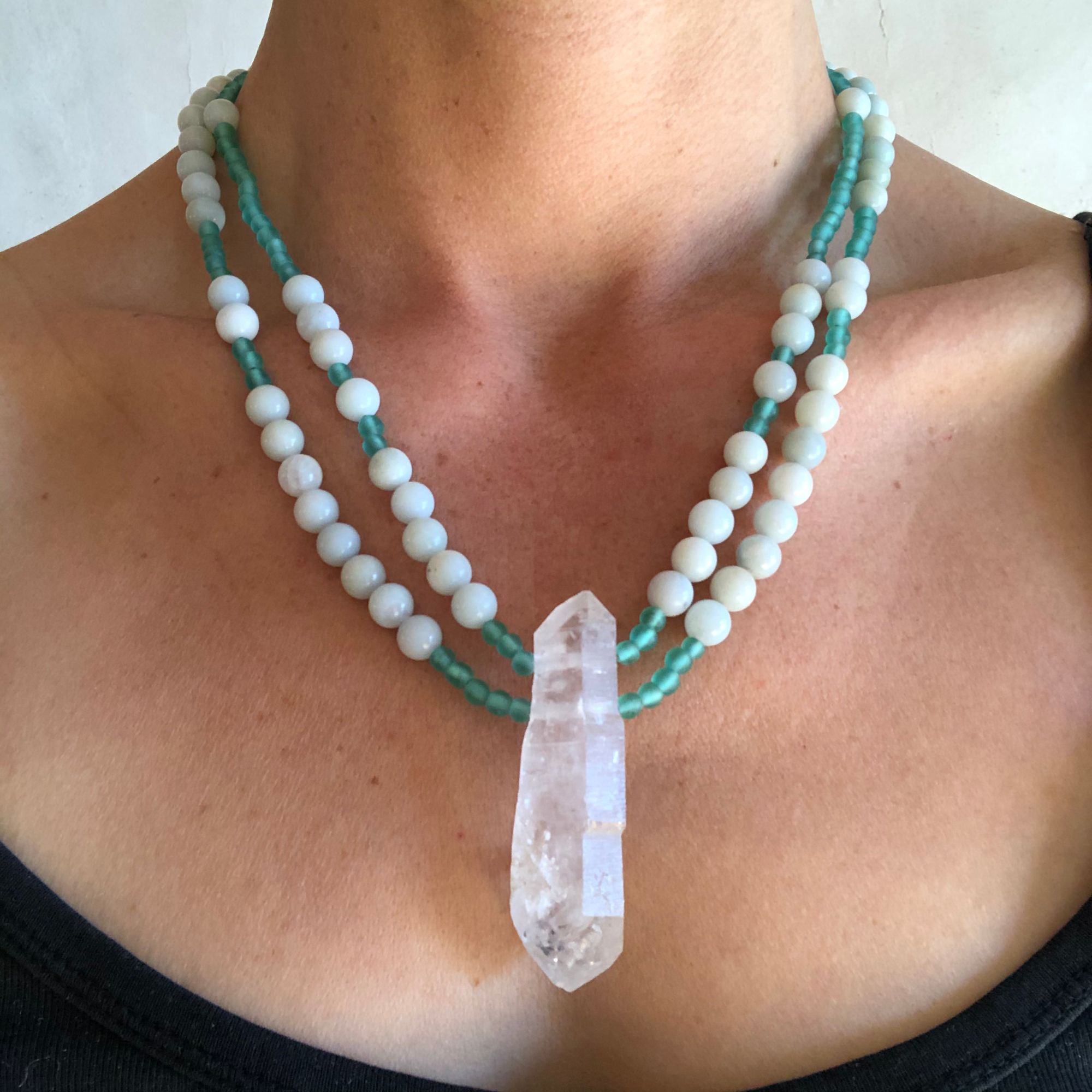 Woman wearing green necklace made of quartz, amazonite and glass beads