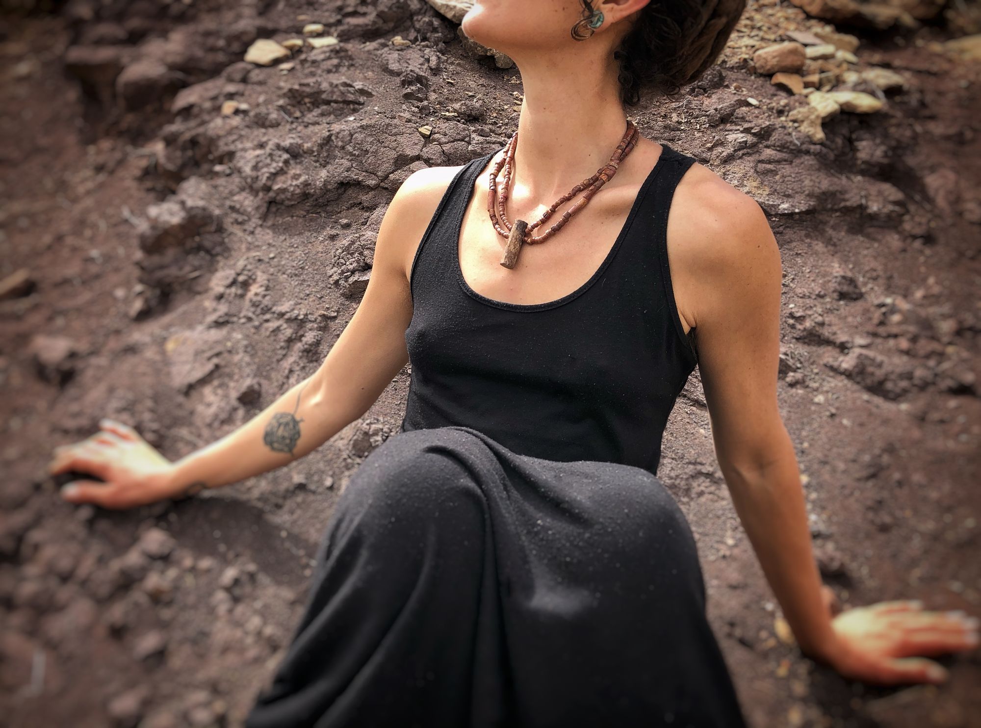 Woman in a black dress wearing stone necklace 