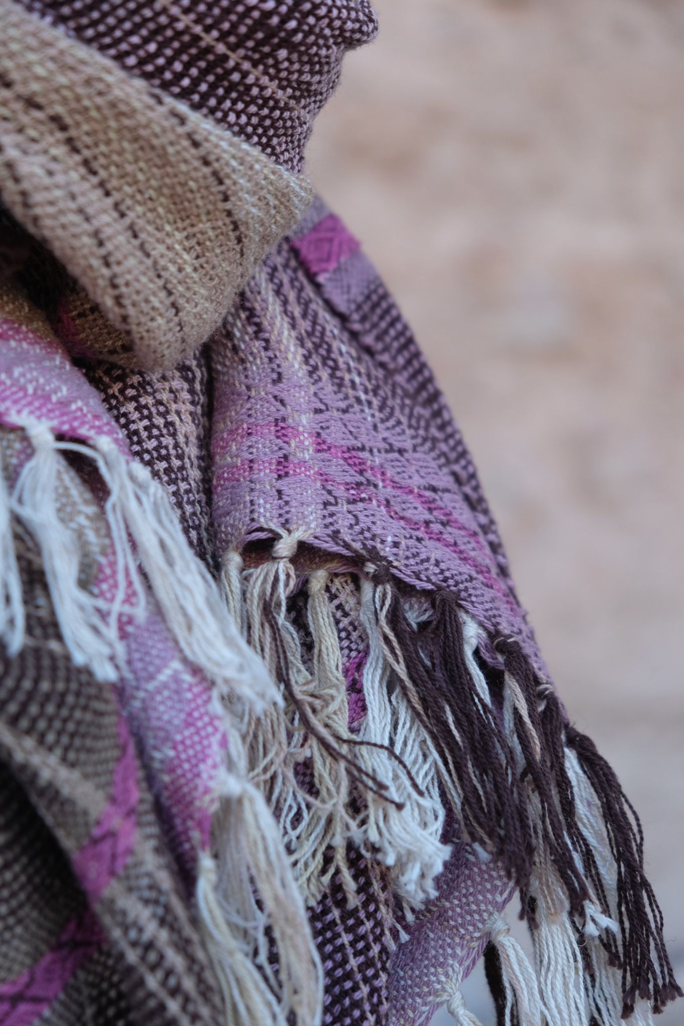 Naturally dyed brown, pink and purple handwoven scarf on a white mannequin 