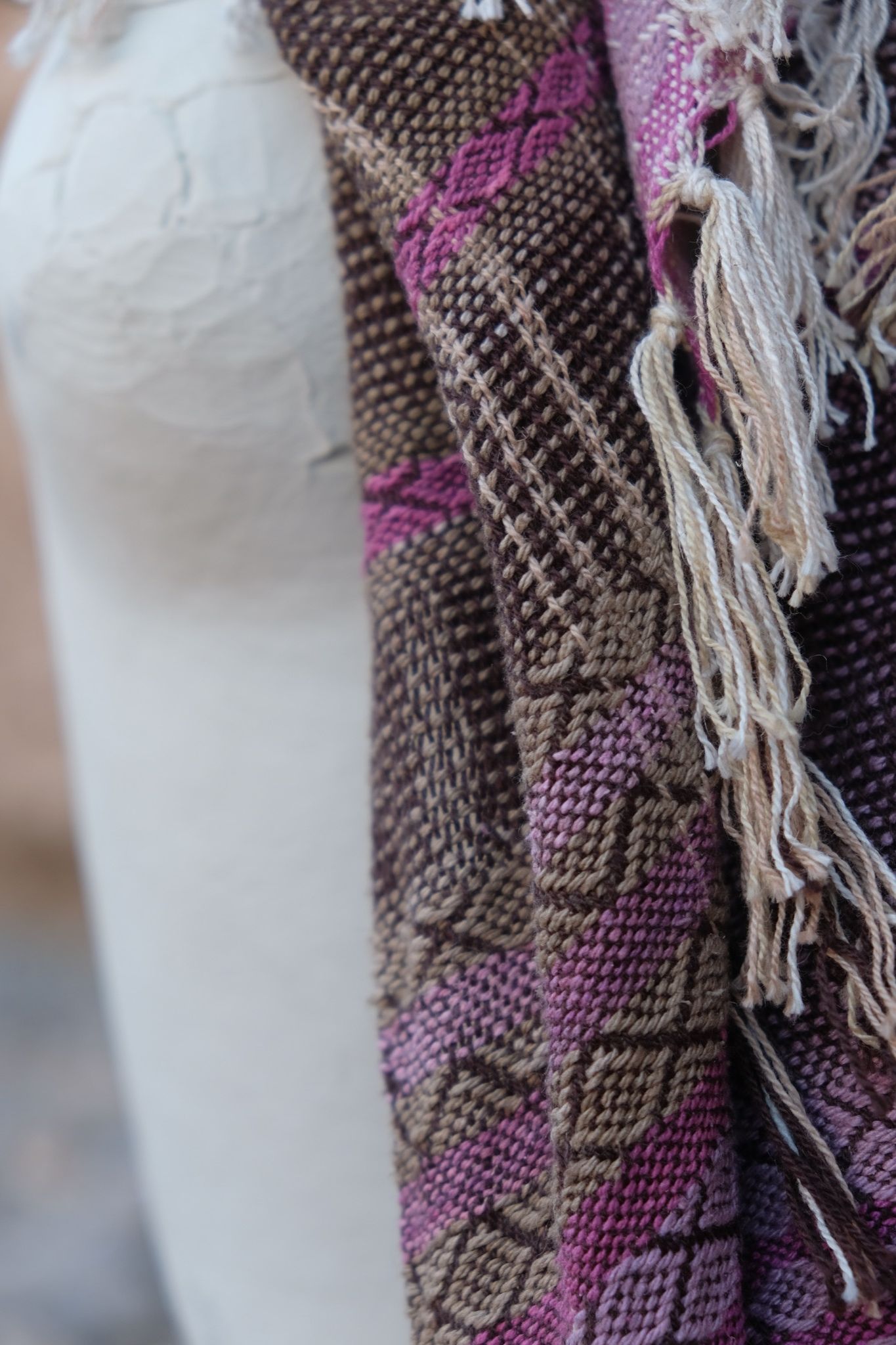 Naturally dyed brown, pink and purple handwoven scarf on a white mannequin 