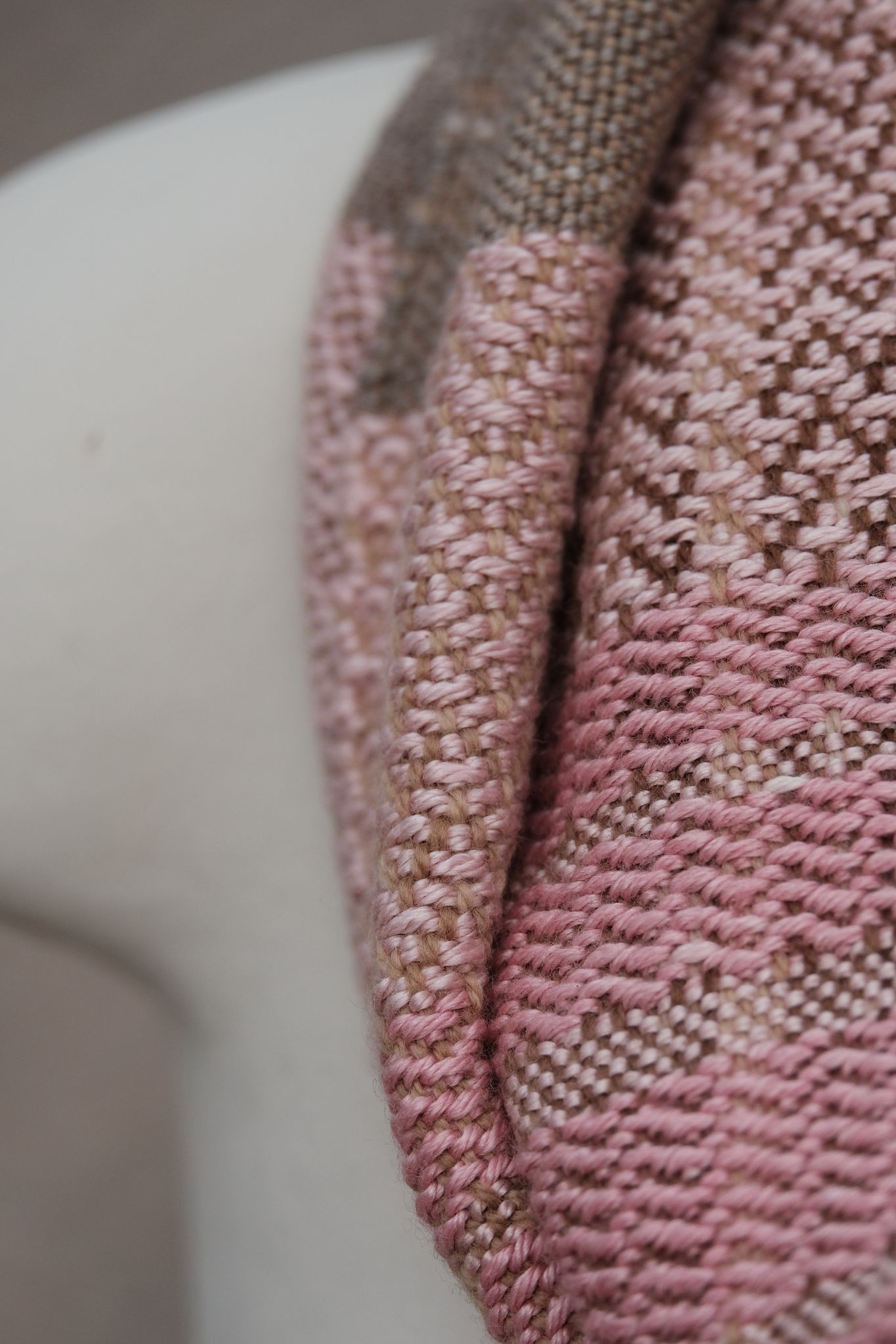 close up of pink and brown handwoven scarf on white mannequin 