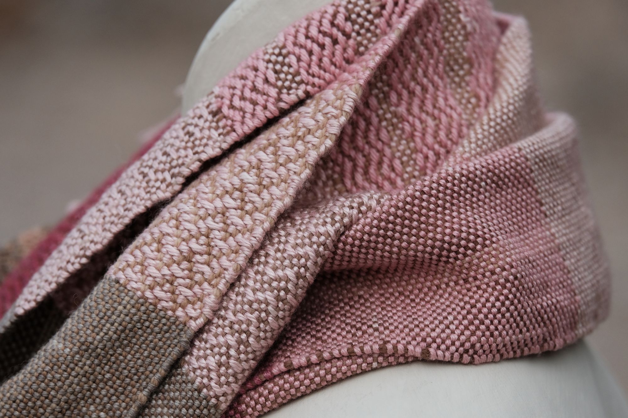 close up of pink and brown handwoven scarf on white mannequin 