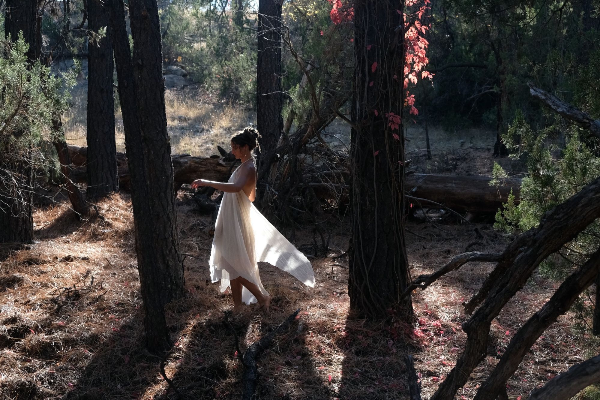 woman wearing white layered silk handmade dress in the forest