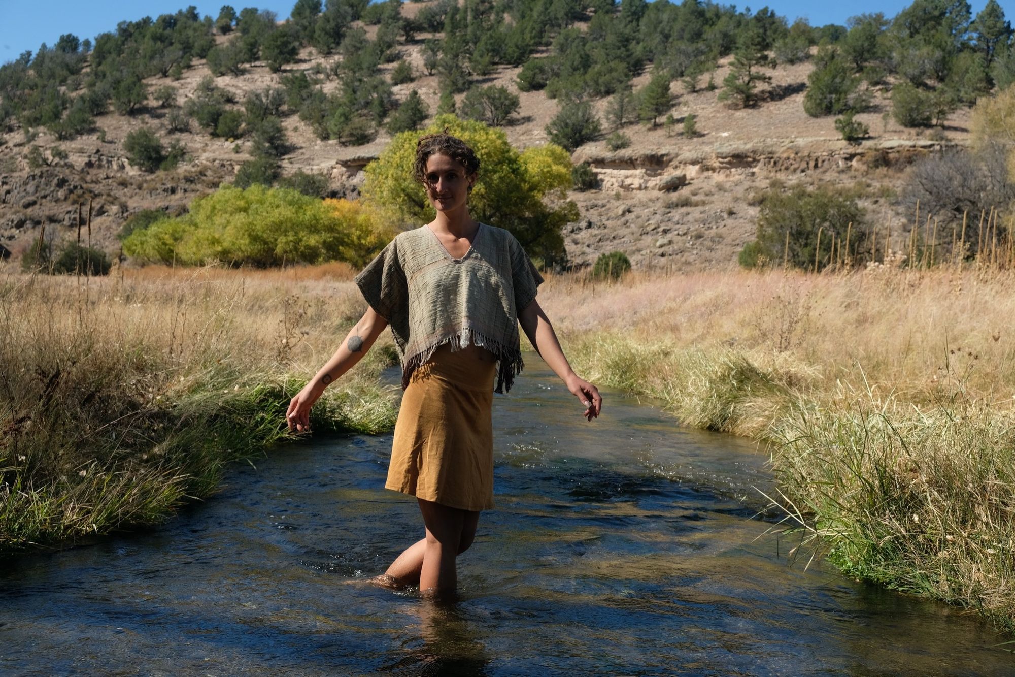 woman wearing tan and dark brown Handspun handwoven Colorgrown Cotton Box Top while standing in a creek