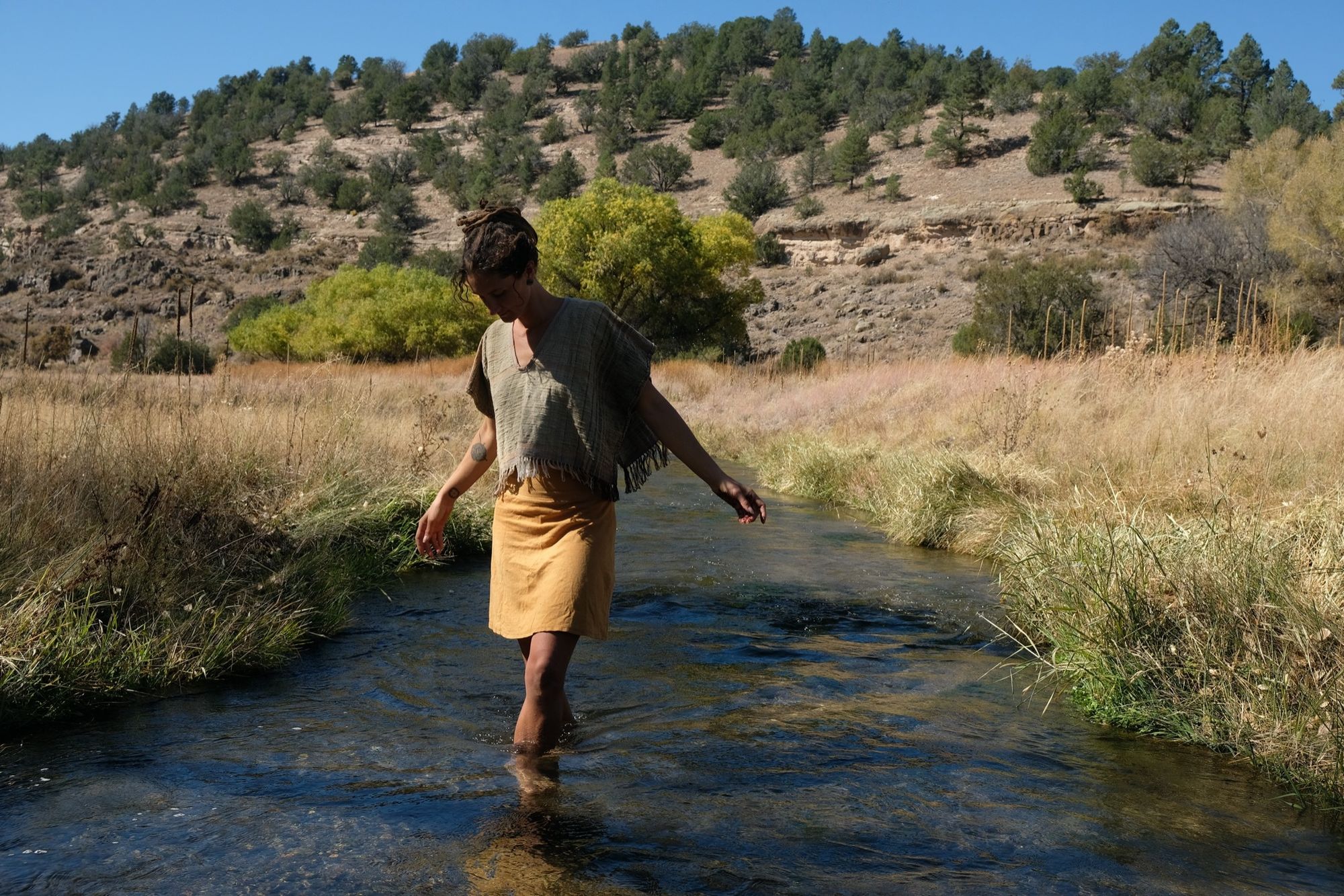 woman wearing tan and dark brown Handspun handwoven Colorgrown Cotton Box Top while standing in a creek