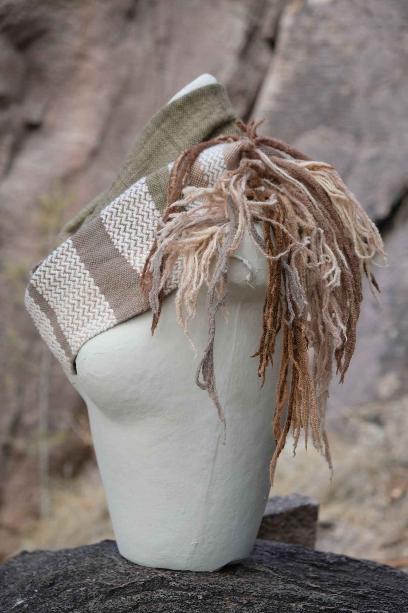 Highly textured and fringy wool and cashmere cowl scarf in green, tan and brown on a white mannequin