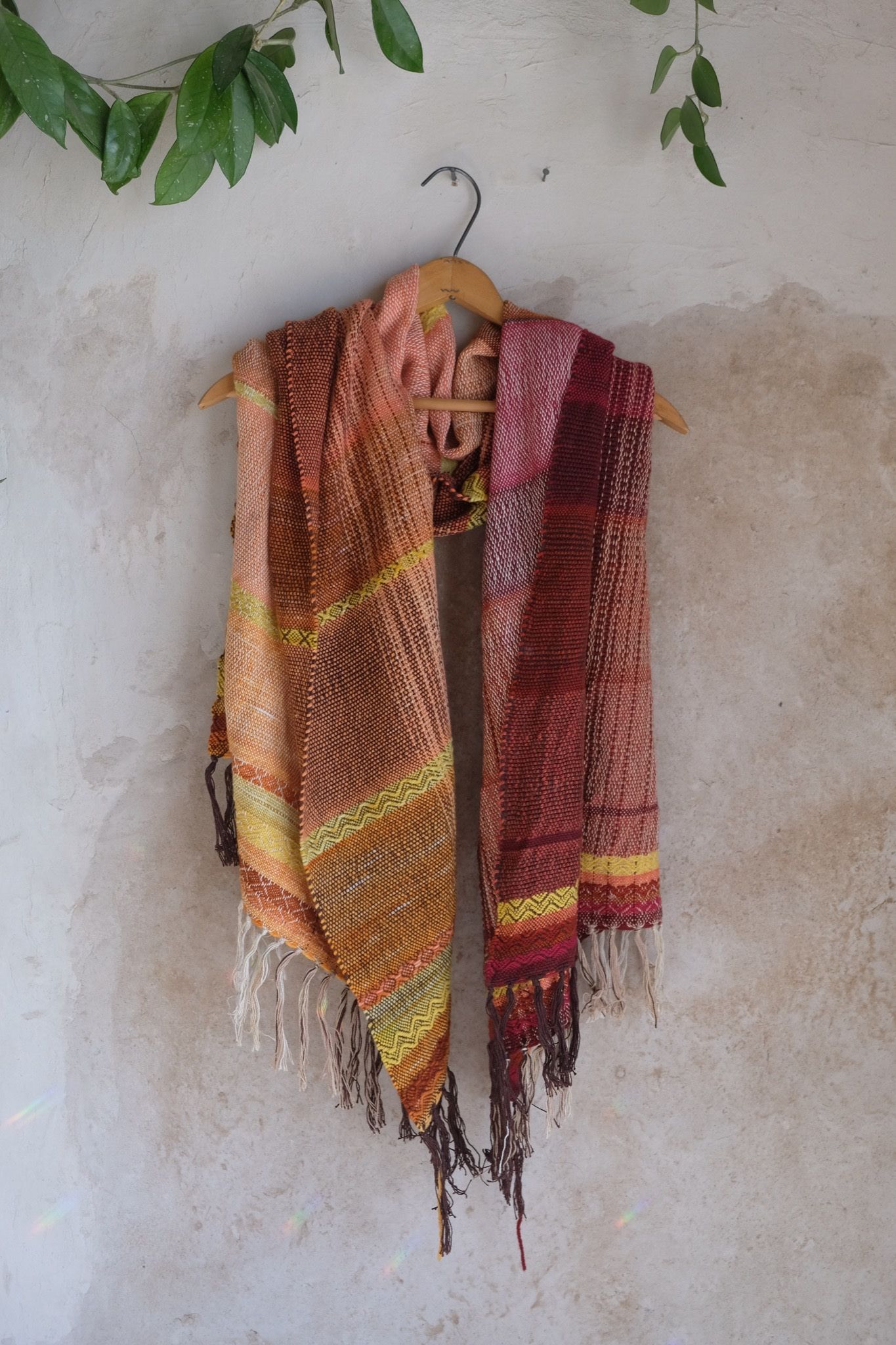 Handwoven red, orange, yellow, brown and white Merino Etherial Scarf on a hanger