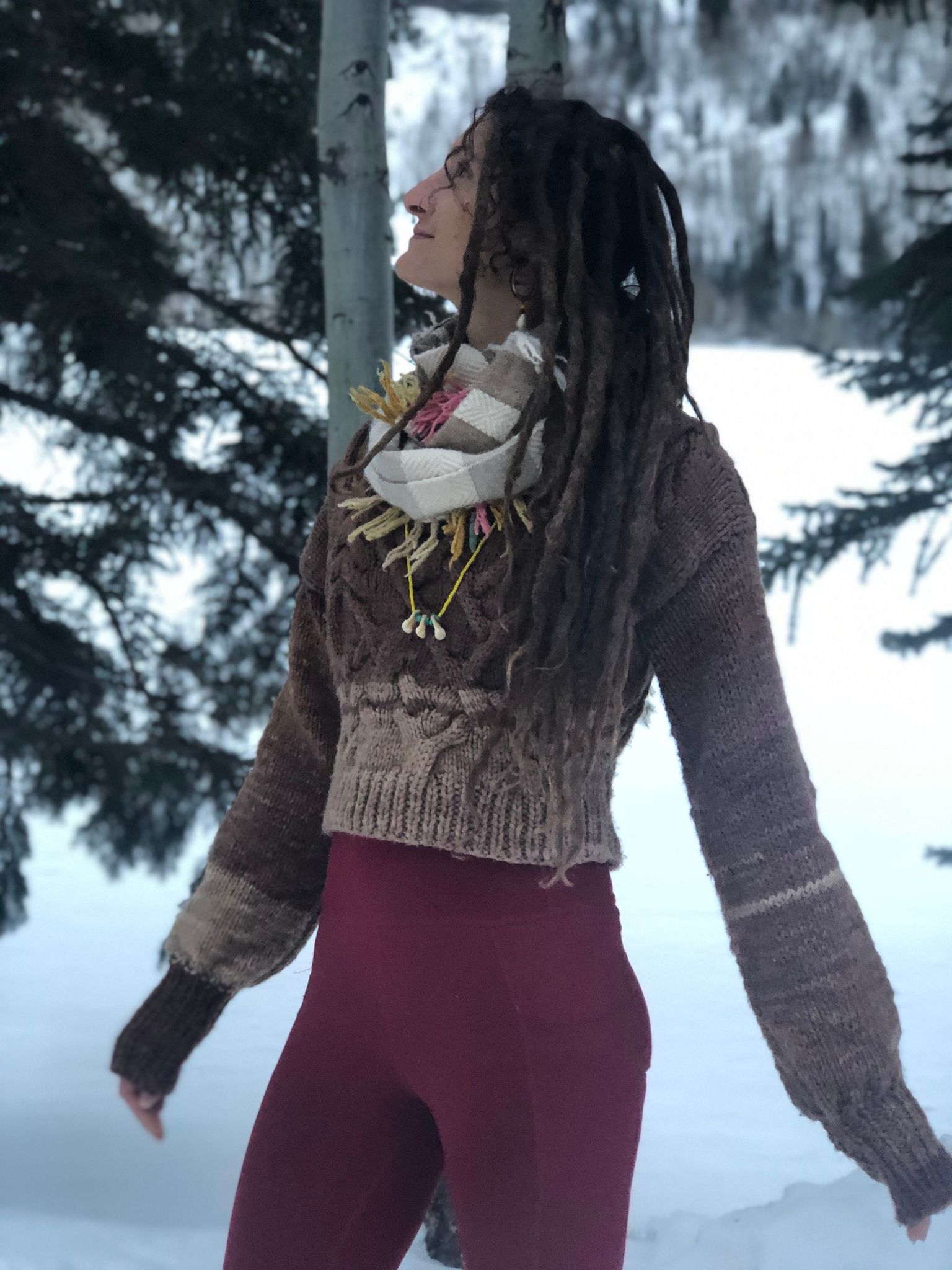 woman wearing Hand knit black walnut dyed sweater while standing in the snow