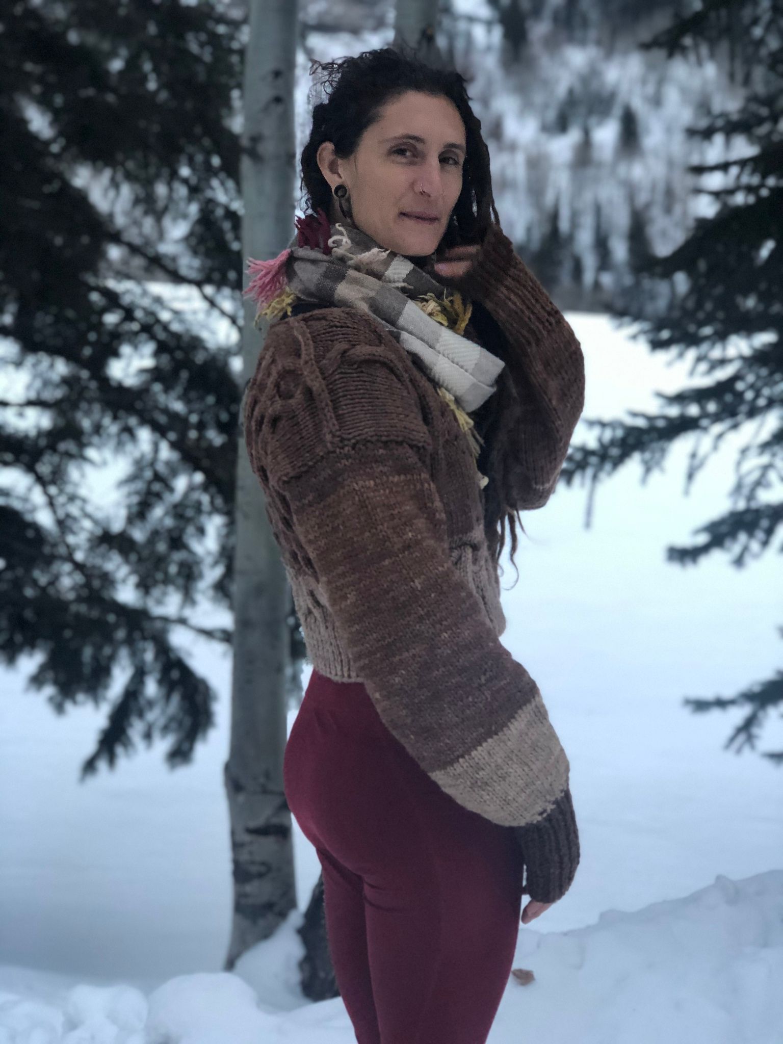 woman wearing Hand knit black walnut dyed sweater while standing in the snow