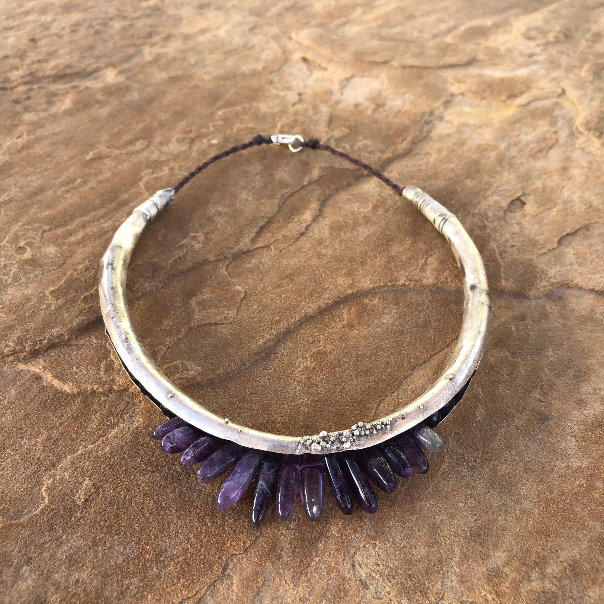 silver hoop necklace with purple amethyst spears protruding from the bottom.