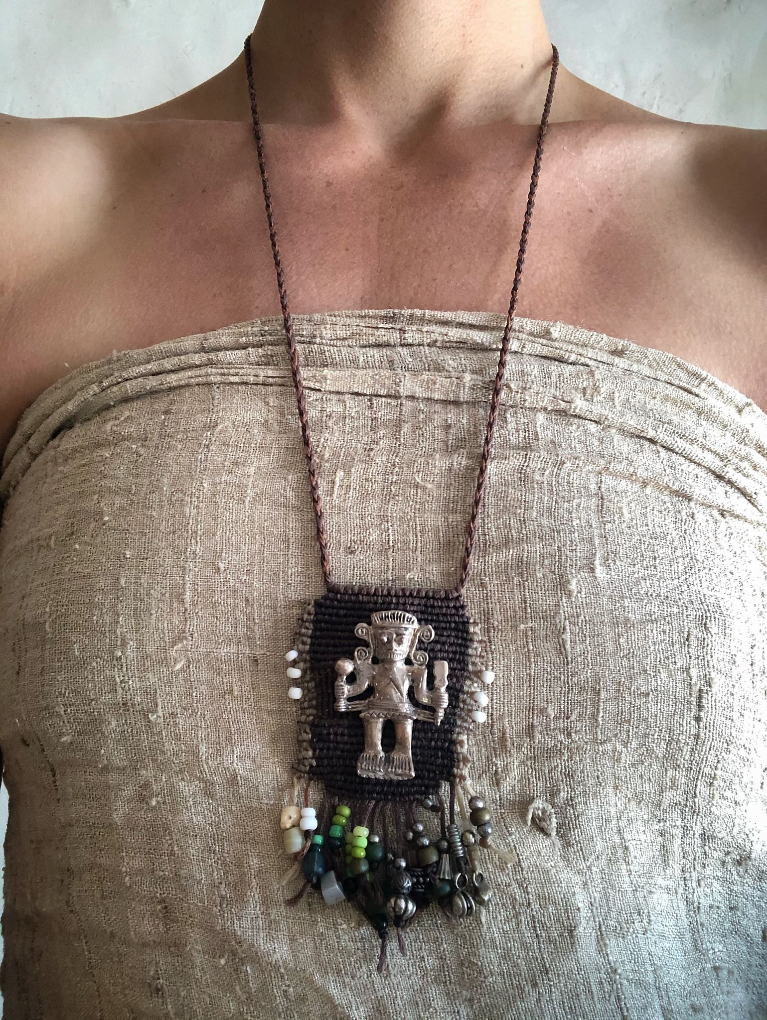 Image of a necklace with silver talisman 