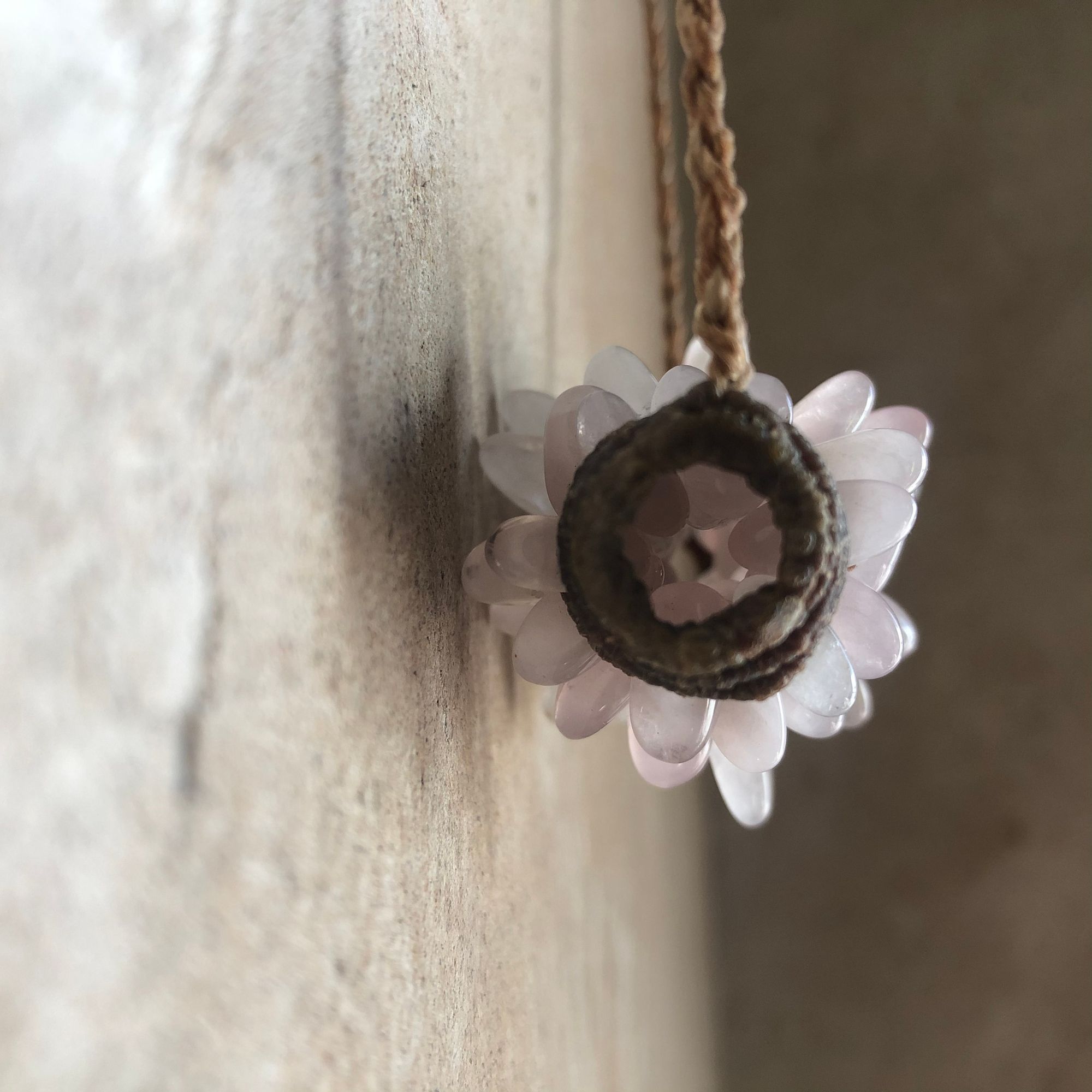 Freeform knot work tube necklace with rose quartz spears protruding from it 