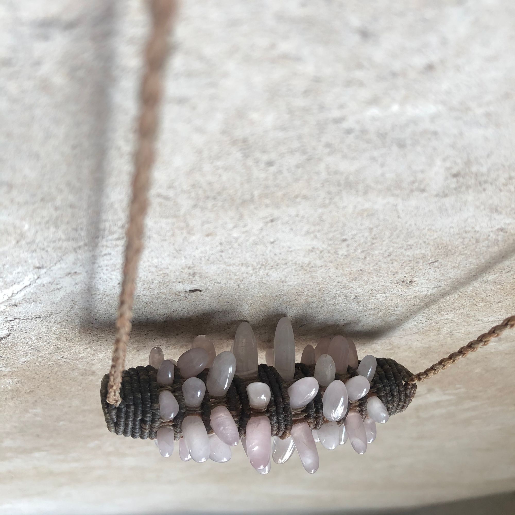 Freeform knot work tube necklace with rose quartz spears protruding from it 