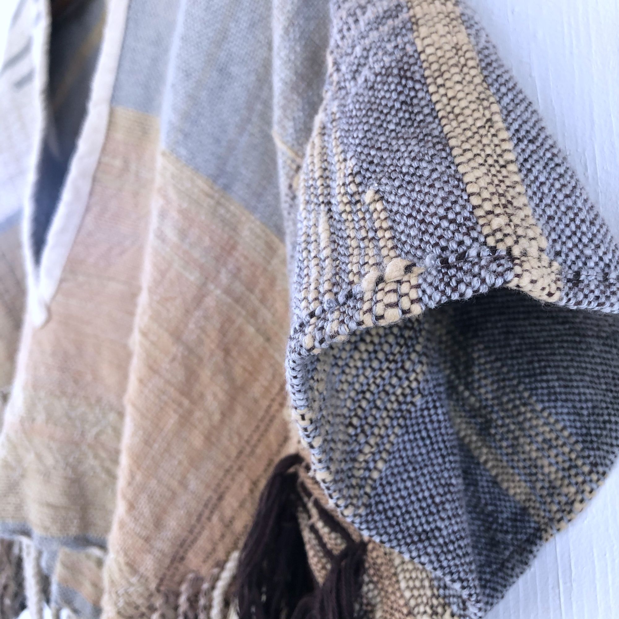 detail of Handwoven blue, tan and brown Handspun Cotton box Top hanging on a white wall