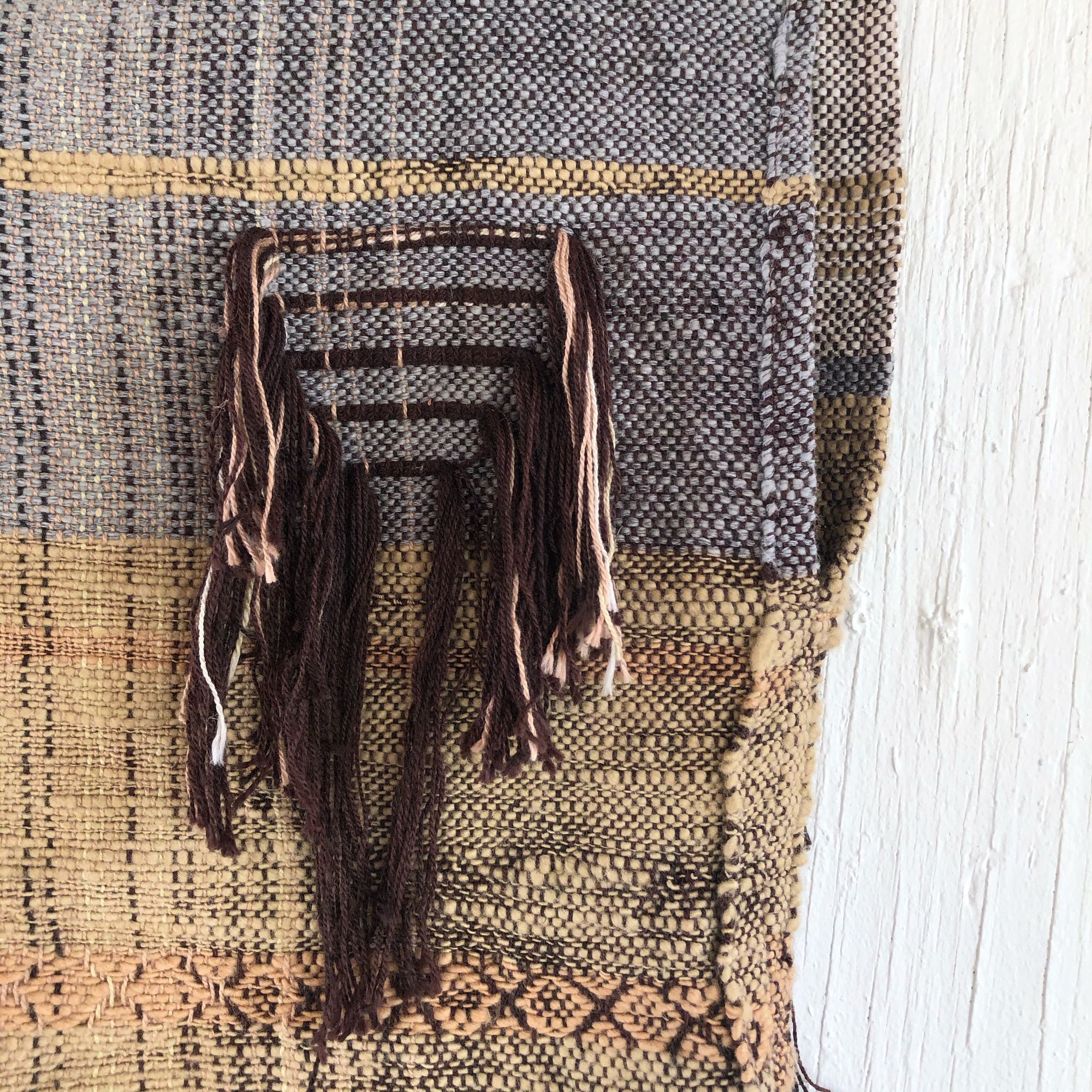 Handwoven blue, tan and brown Handspun Cotton box Top hanging on a white wall