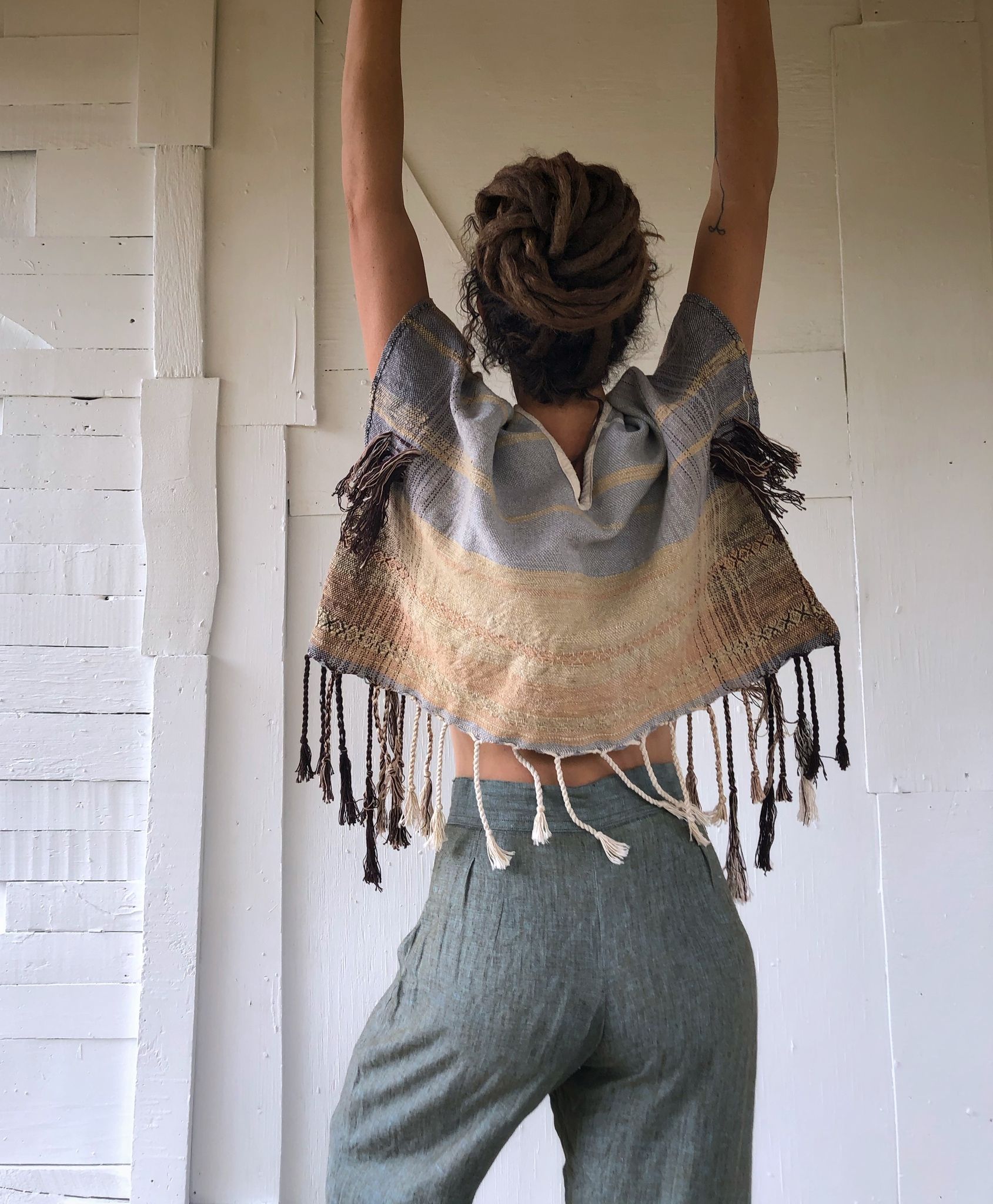 Woman wearing Handwoven blue, tan and brown Handspun Cotton box Top with blue pants