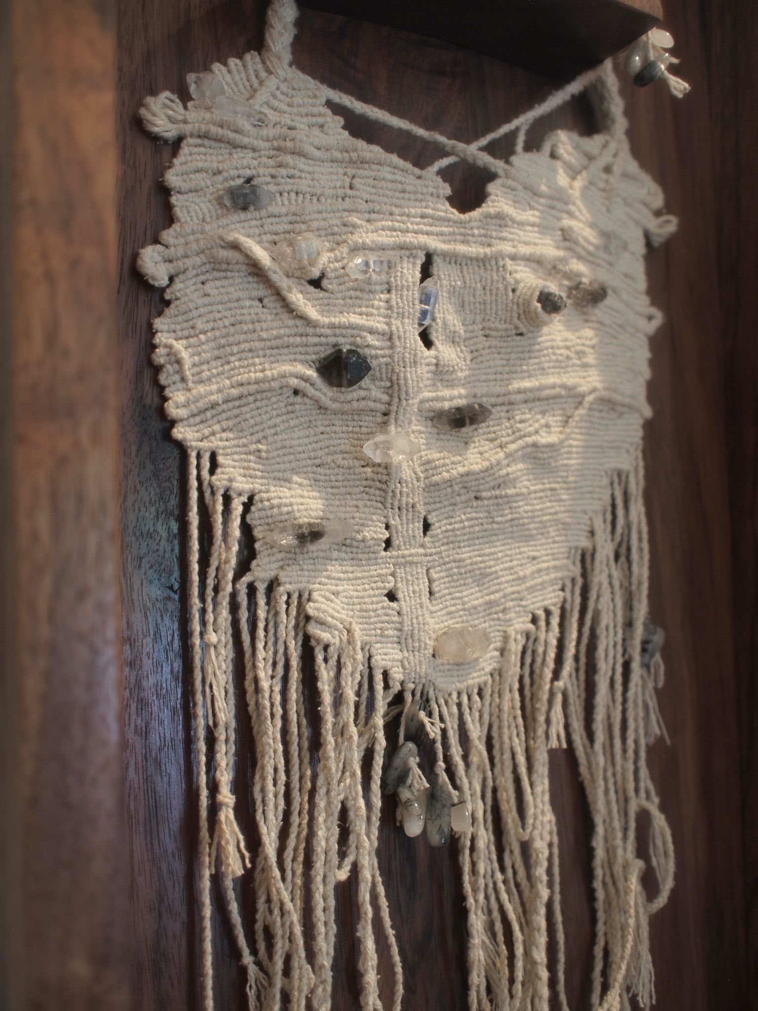 Detail of silk knot work and smoky quartz sculptural adornment in a dark wood box