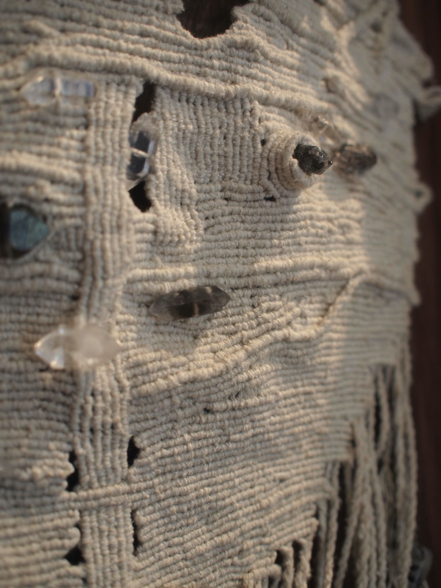 Detail of silk knot work and smoky quartz sculptural adornment in a dark wood box