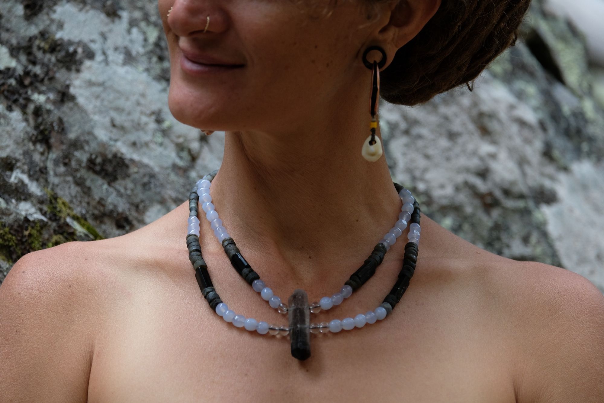 Woman wearing two strand necklace with Smoky quartz, quartz, luminous blue carnelian, labradorite and black tourmaline