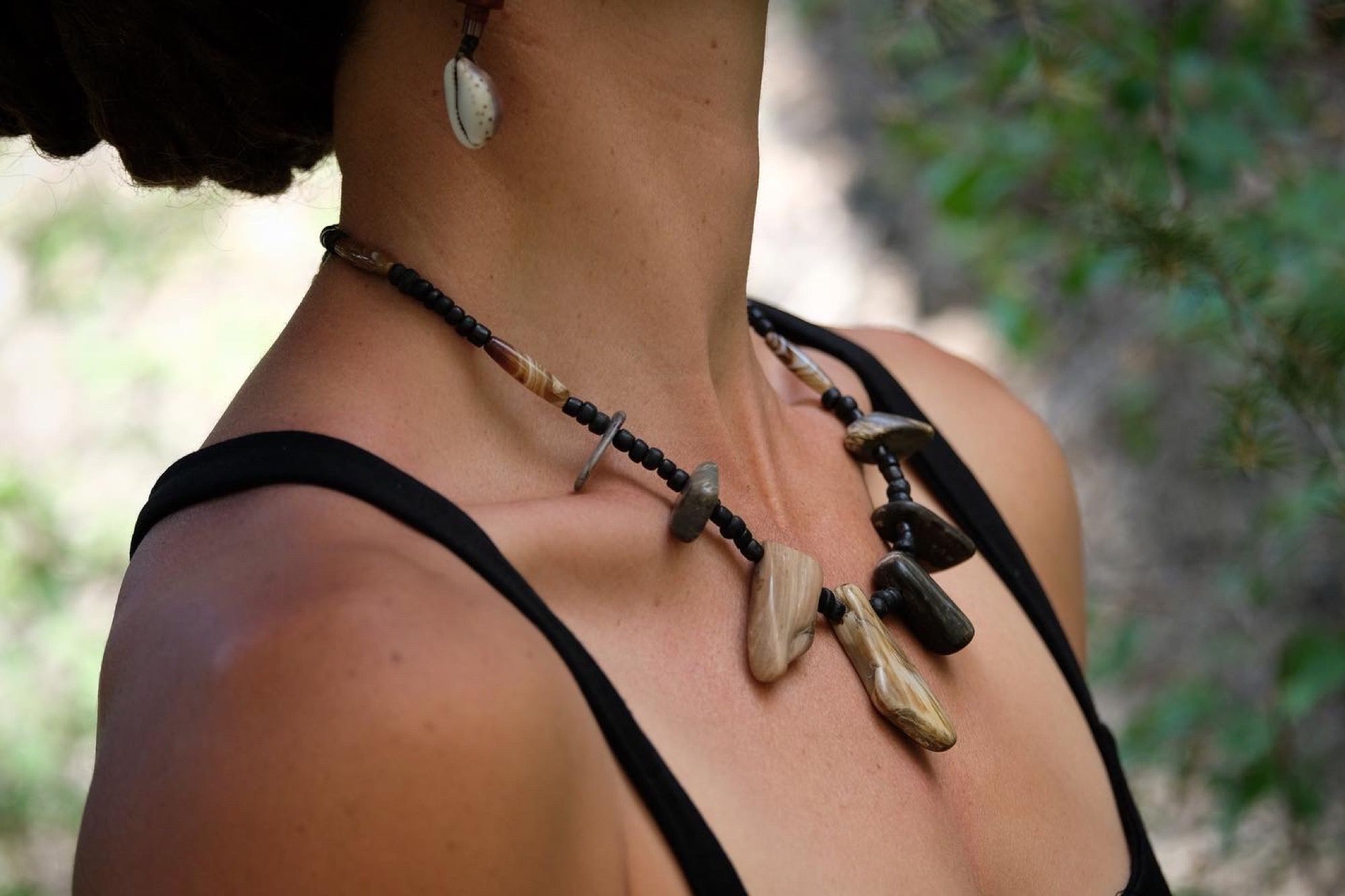 Woman wearing necklace with petrified wood and black beads