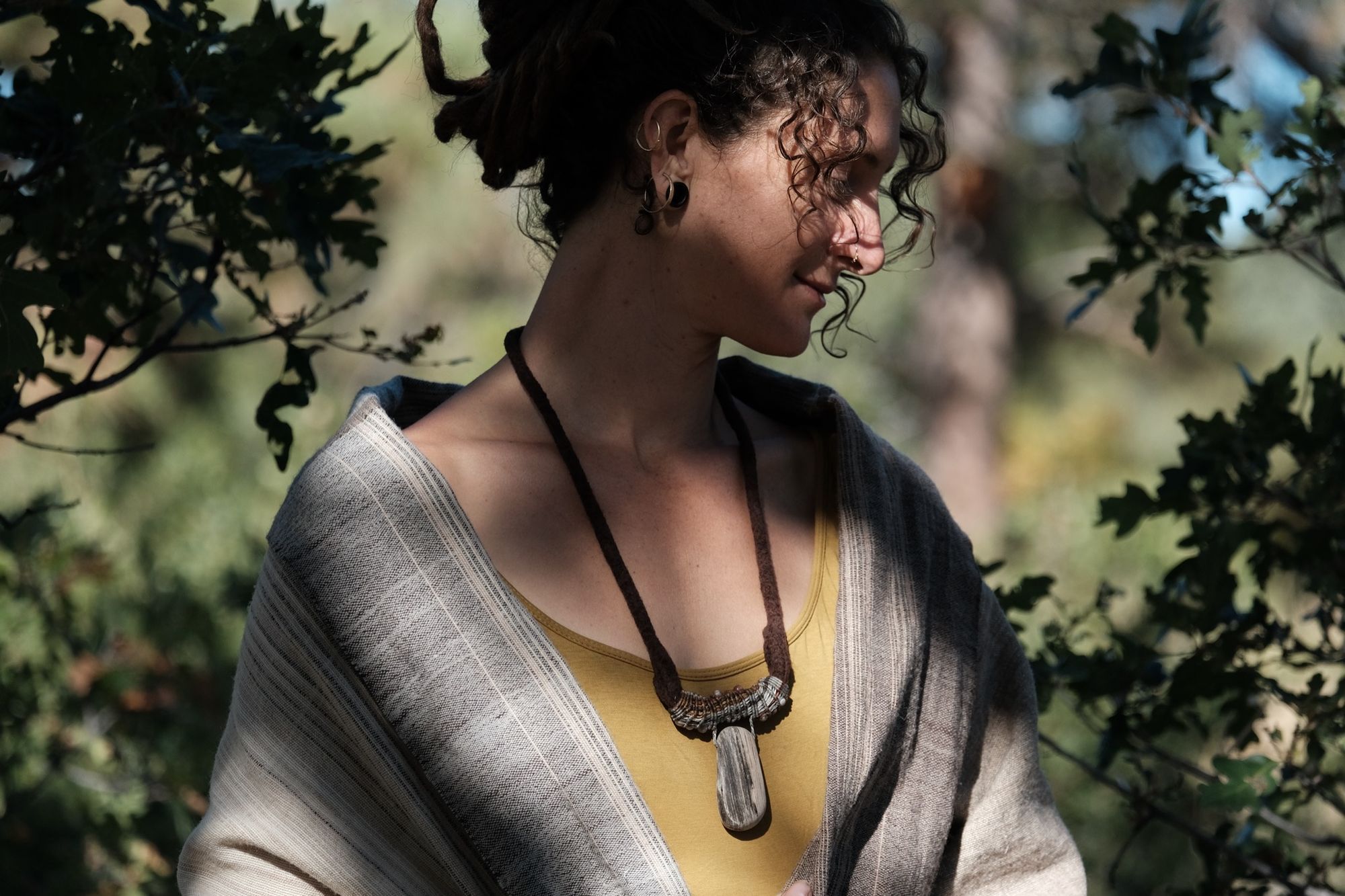 Woman wearing chartreuse shirt and sculptural necklace made of brown felt, petrified wood and grey-brown knotwork