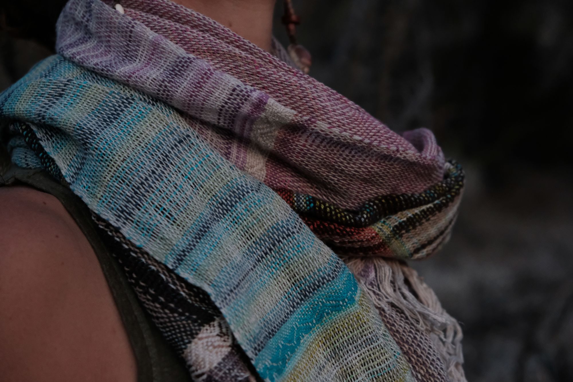 detail of Woman wearing a blue, purple, white, brown and green scarf in the desert. 