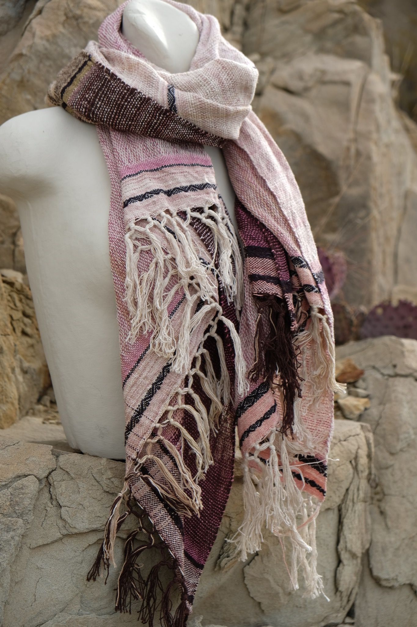 pink, black and white cotton and silks scarf with fringe on a white mannequin bust in the desert