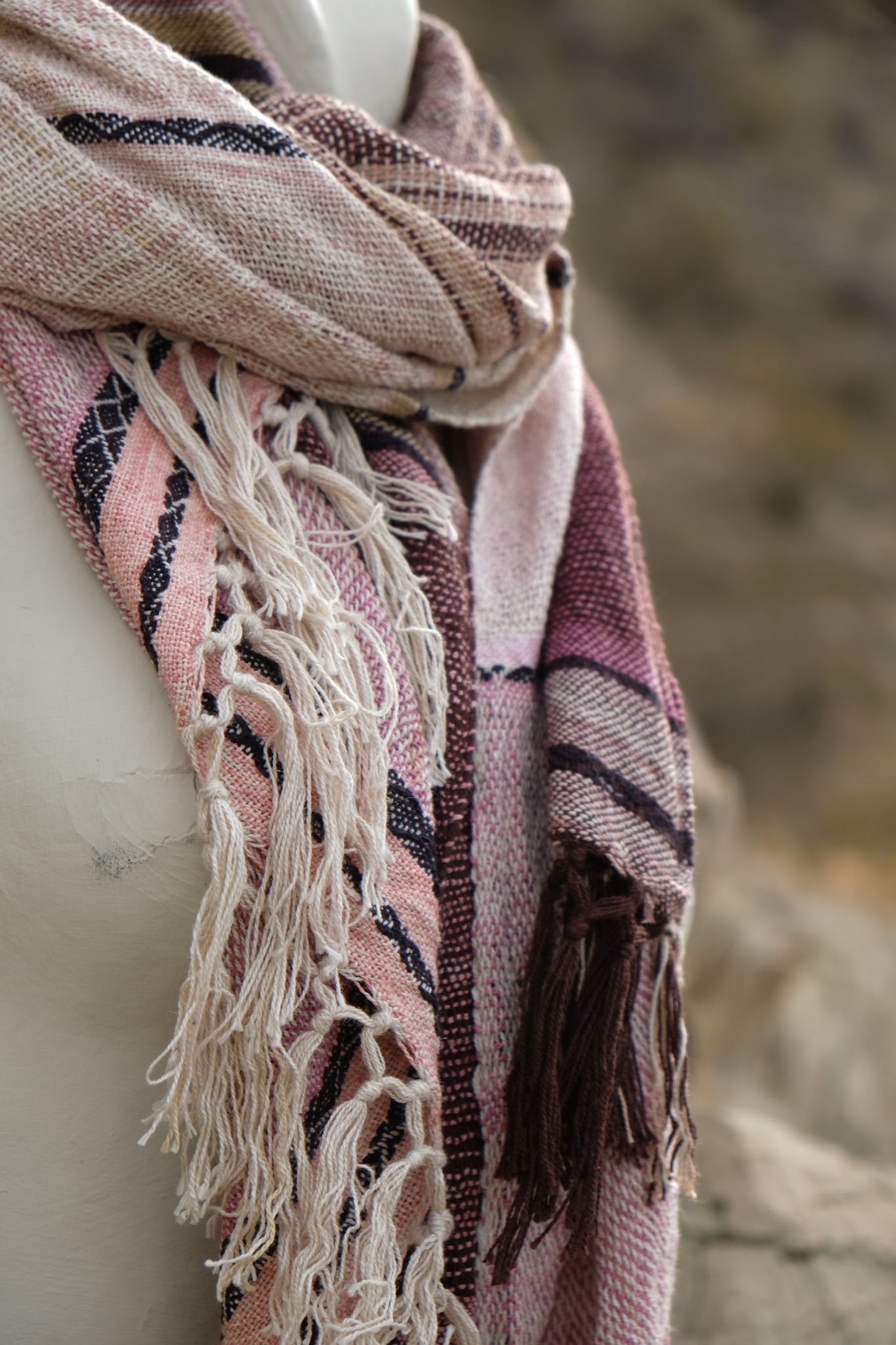 pink, black and white cotton and silks scarf with fringe on a white mannequin bust in the desert