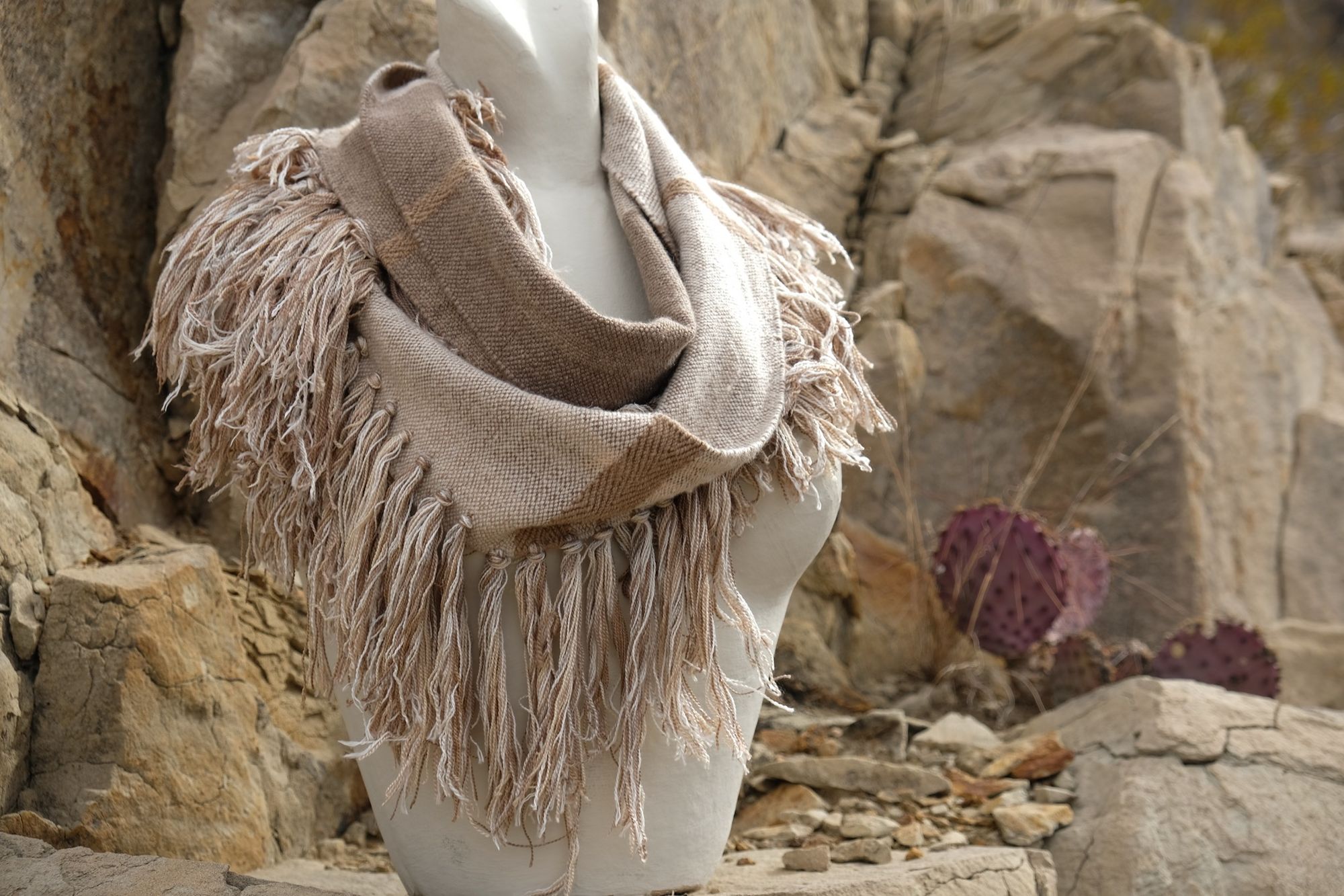  white and brown fringed infinity scarf on a white mannequin bust in the desert