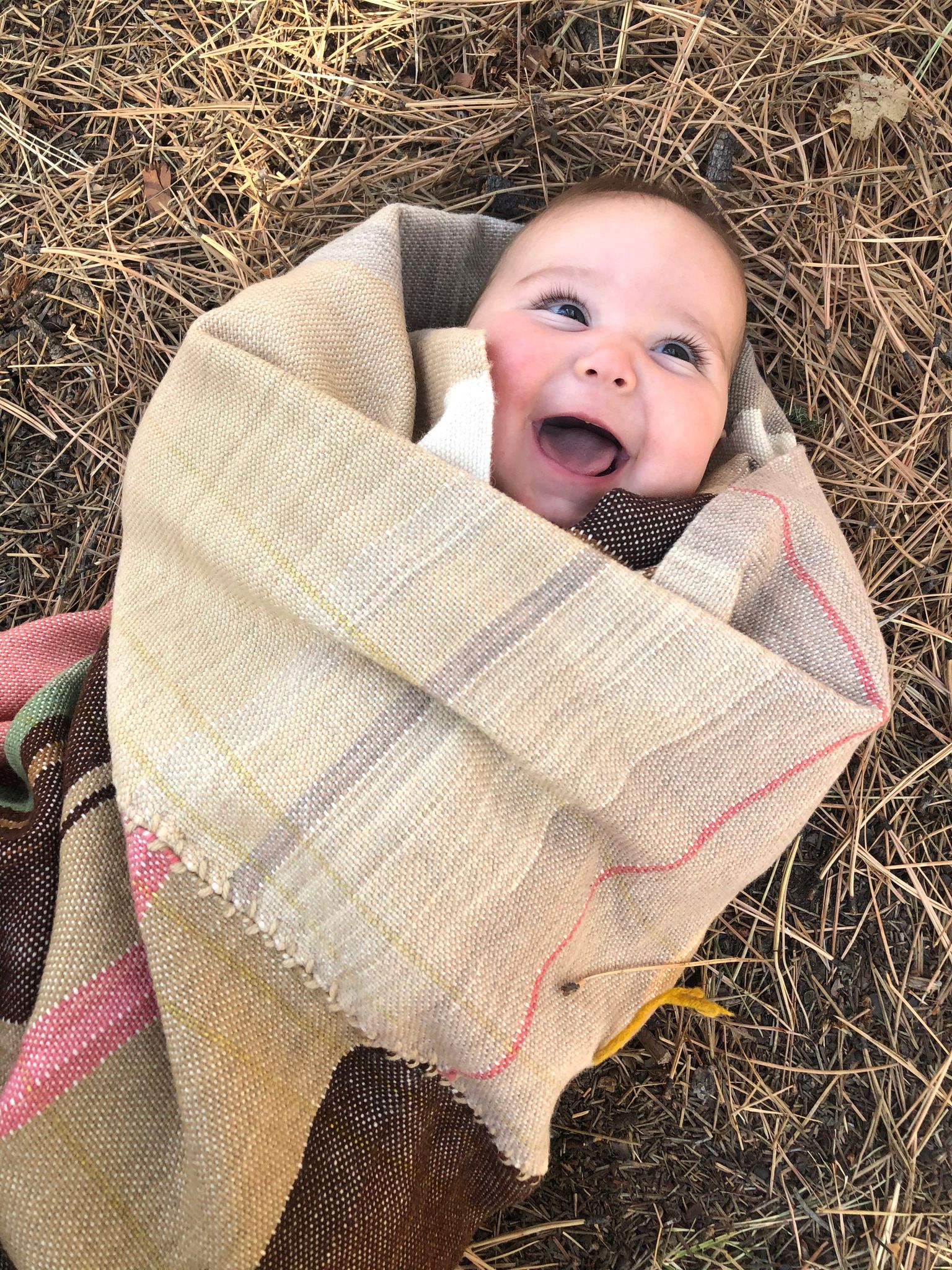 Baby wrapped in Handwoven Naturally Dyed Merino Blanket in the desert