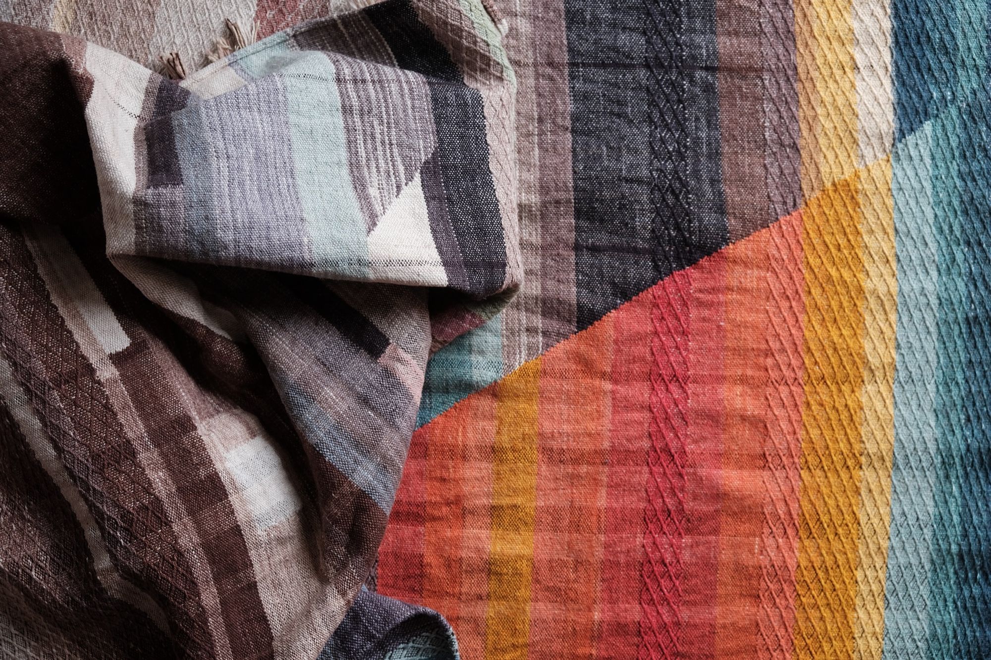 Handwoven fabric with geometric designs of brown, black, grey, red, orange, yellow and blue