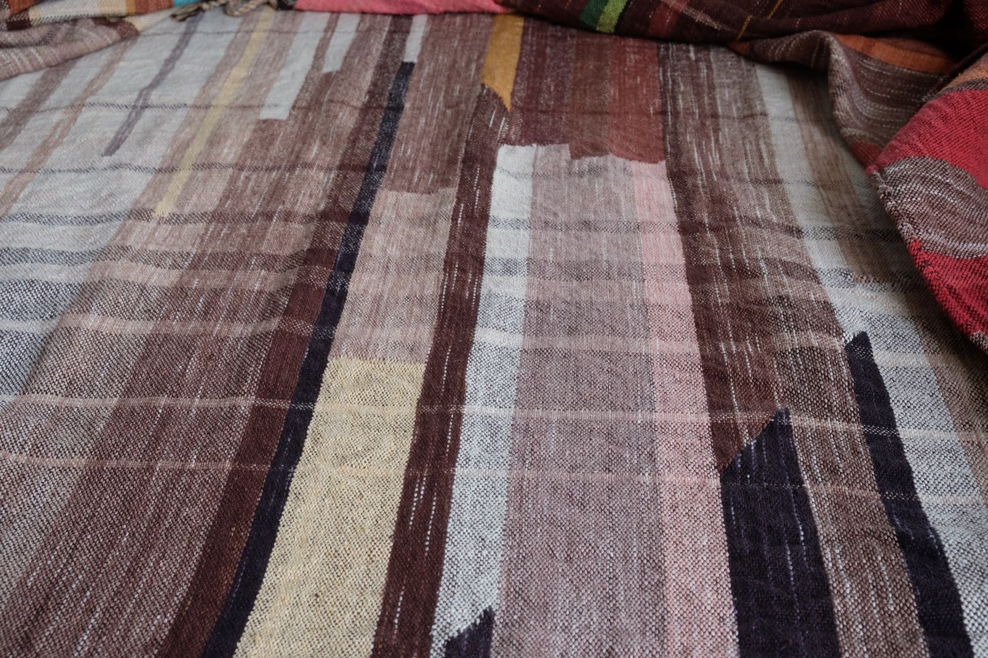 many colored handwoven fabric laying on a wooden floor