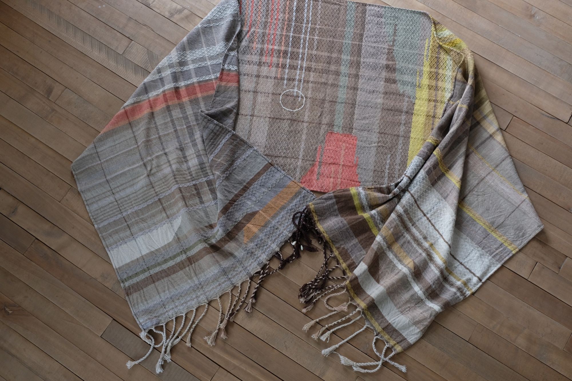 handwoven fabric with textured diamond pattern in soft earth tones of brown, salmon, green peach and yellow