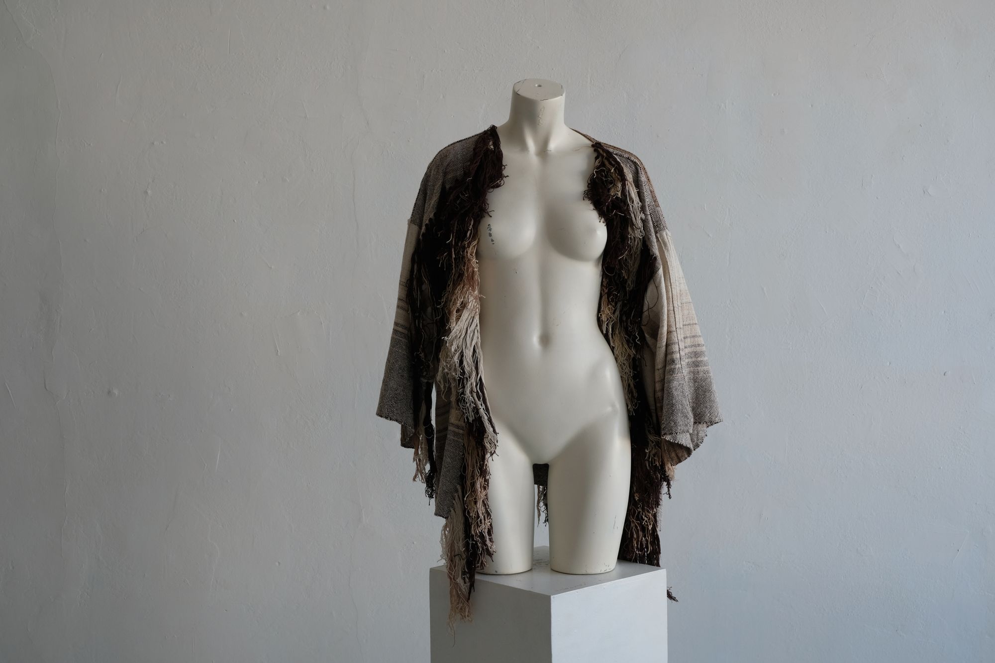  raw silk and organic cotton linen brown, tan and white Handwoven fringed Cloak on a white mannequin in a white room