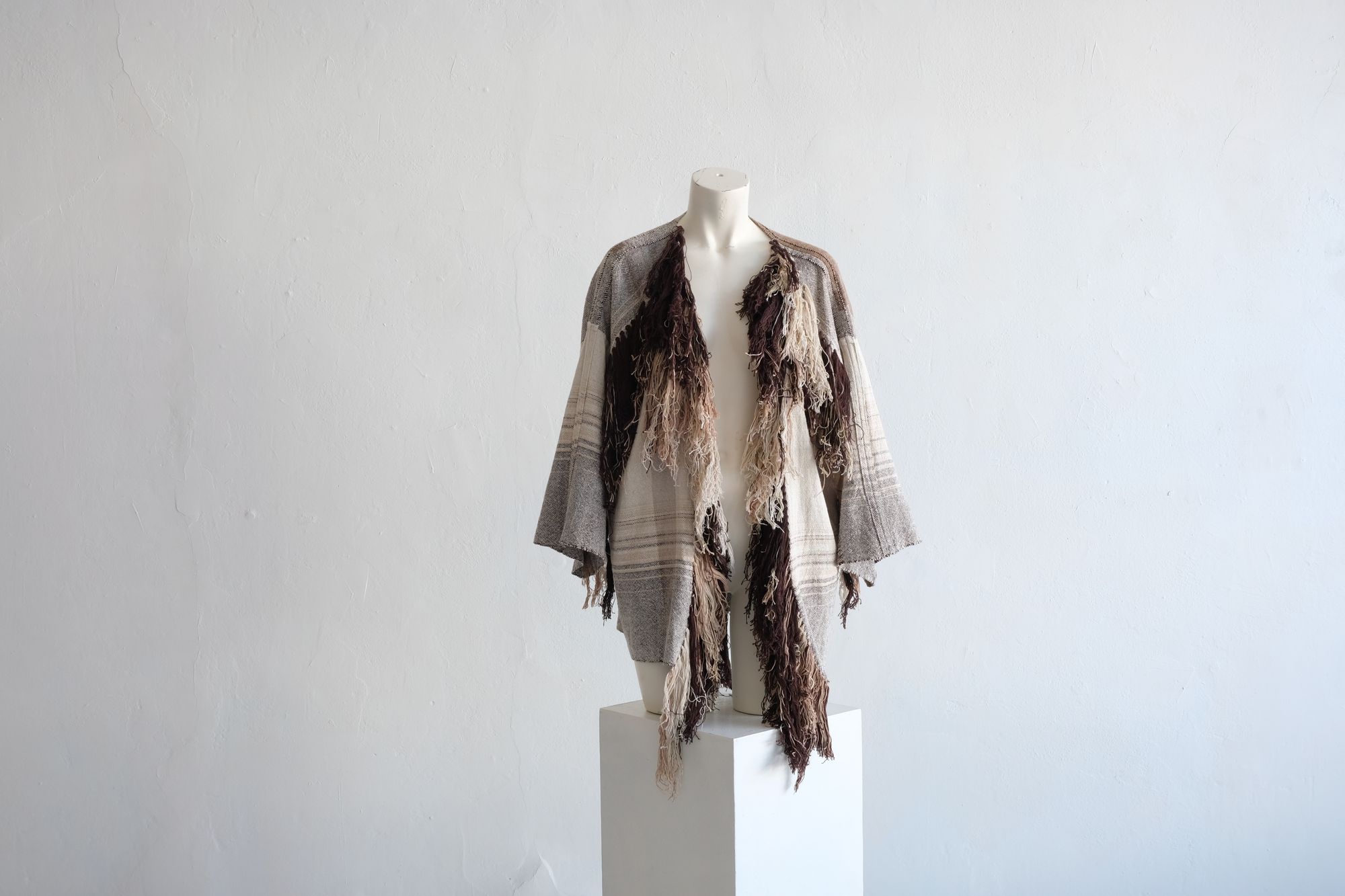  raw silk and organic cotton linen brown, tan and white Handwoven fringed Cloak on a white mannequin in a white room