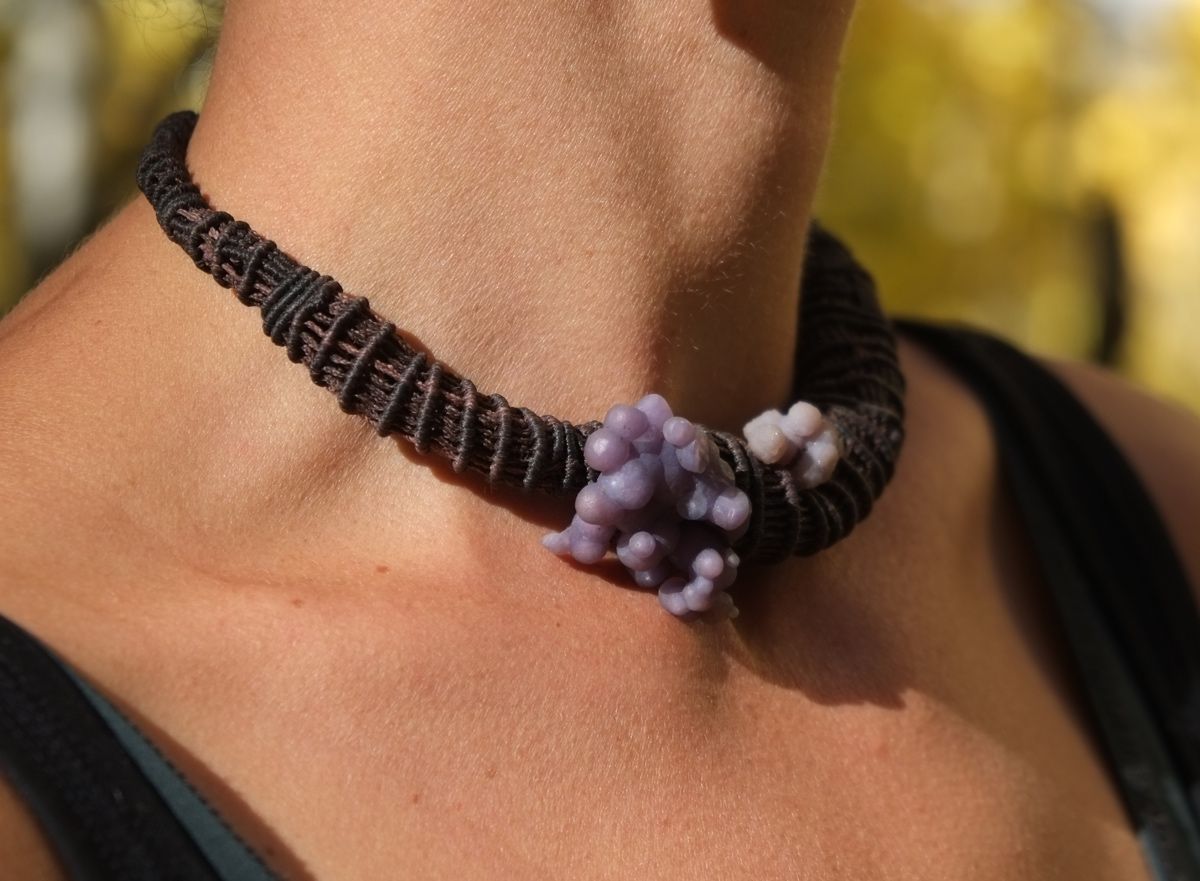 knot work necklace made with dark purple thread and purple grape chalcedony on a woman in the forest