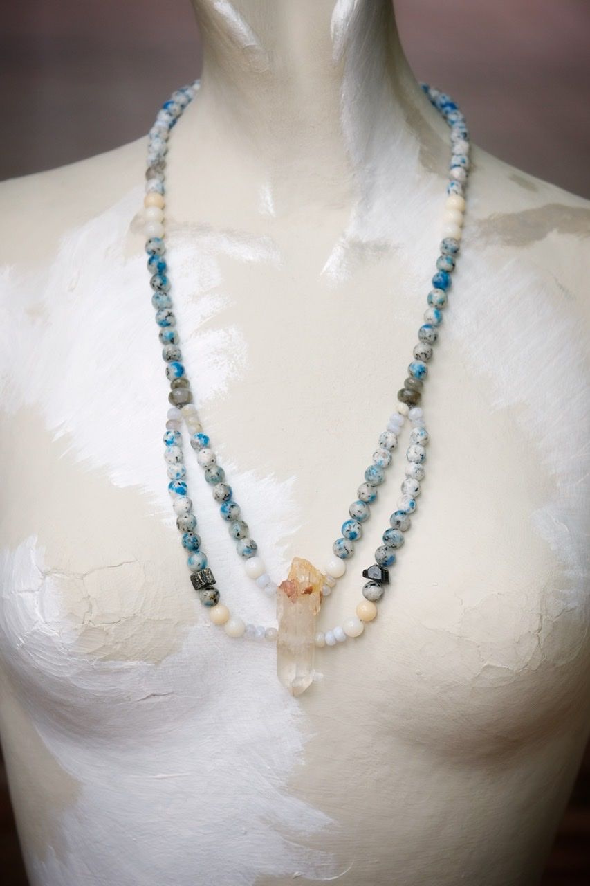 Blue, white and black stone and crystal necklace on a white mannequin 