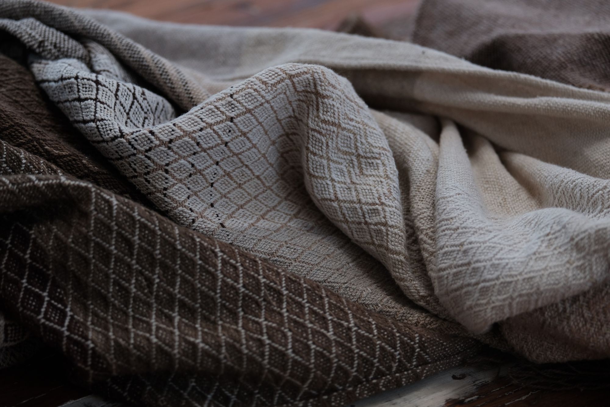 A detail of handwoven softly graded grey to white to brown diamond pattern raw silk fabric