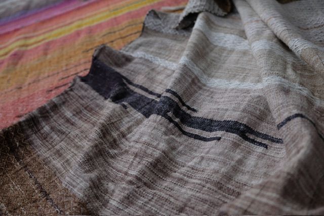 handwoven raw silk fabric with a textured diamond pattern in shades of blue, warm sunset and white-straw-brown
