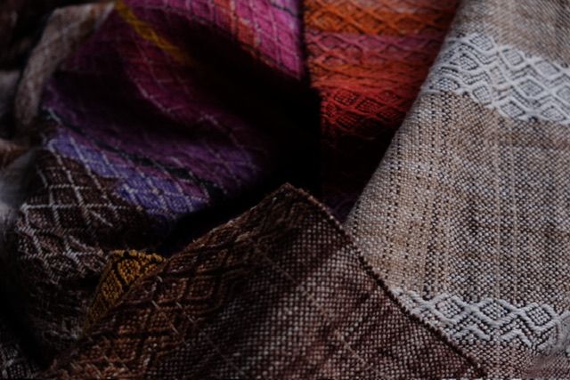 handwoven raw silk fabric with a textured diamond pattern in shades of blue, warm sunset and white-straw-brown
