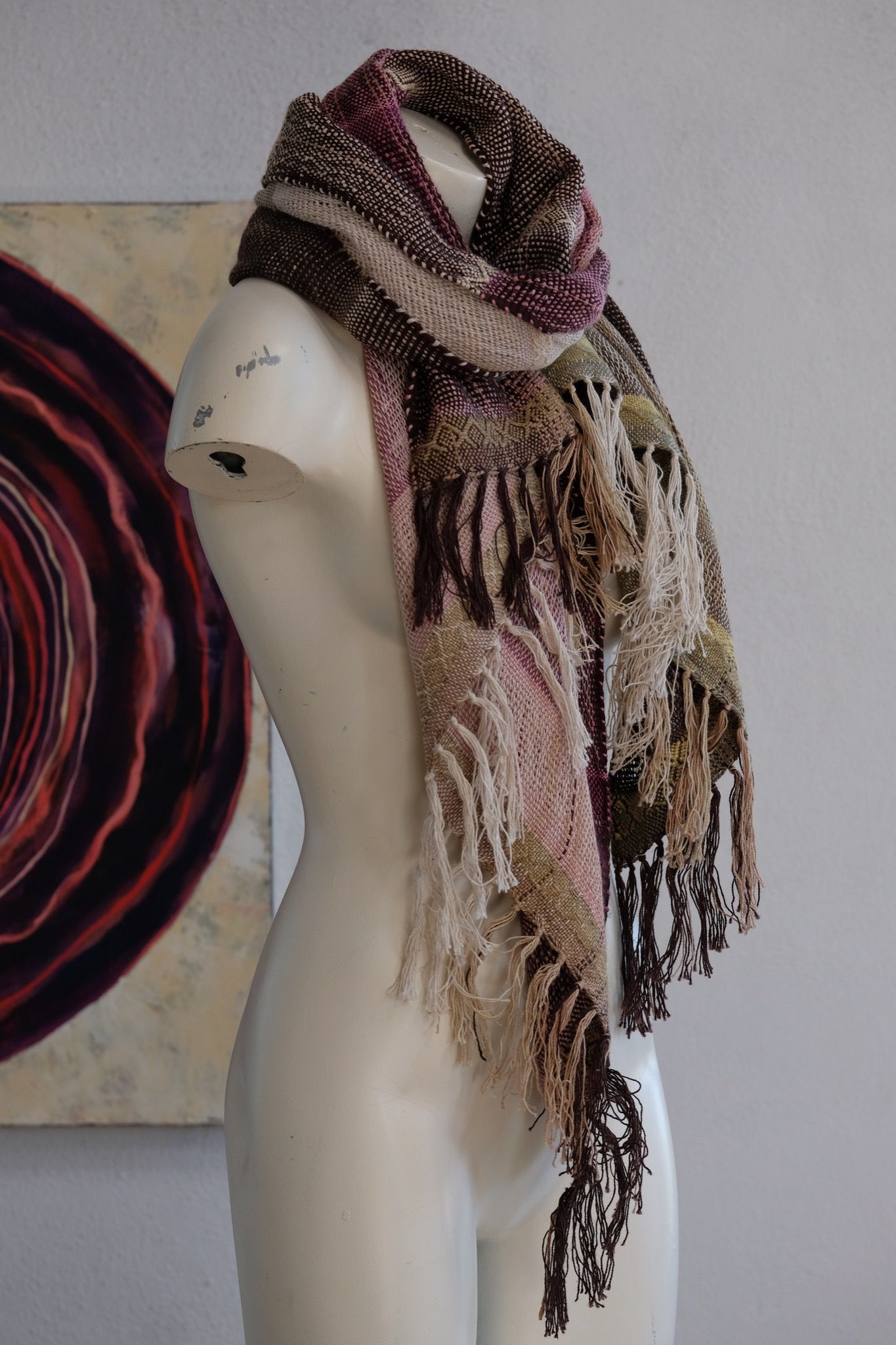 Handwoven organic cotton-linen, tussah silk and silk-merino scarf naturally dyed shades of pink, brown and green on a white mannequin in a white gallery space