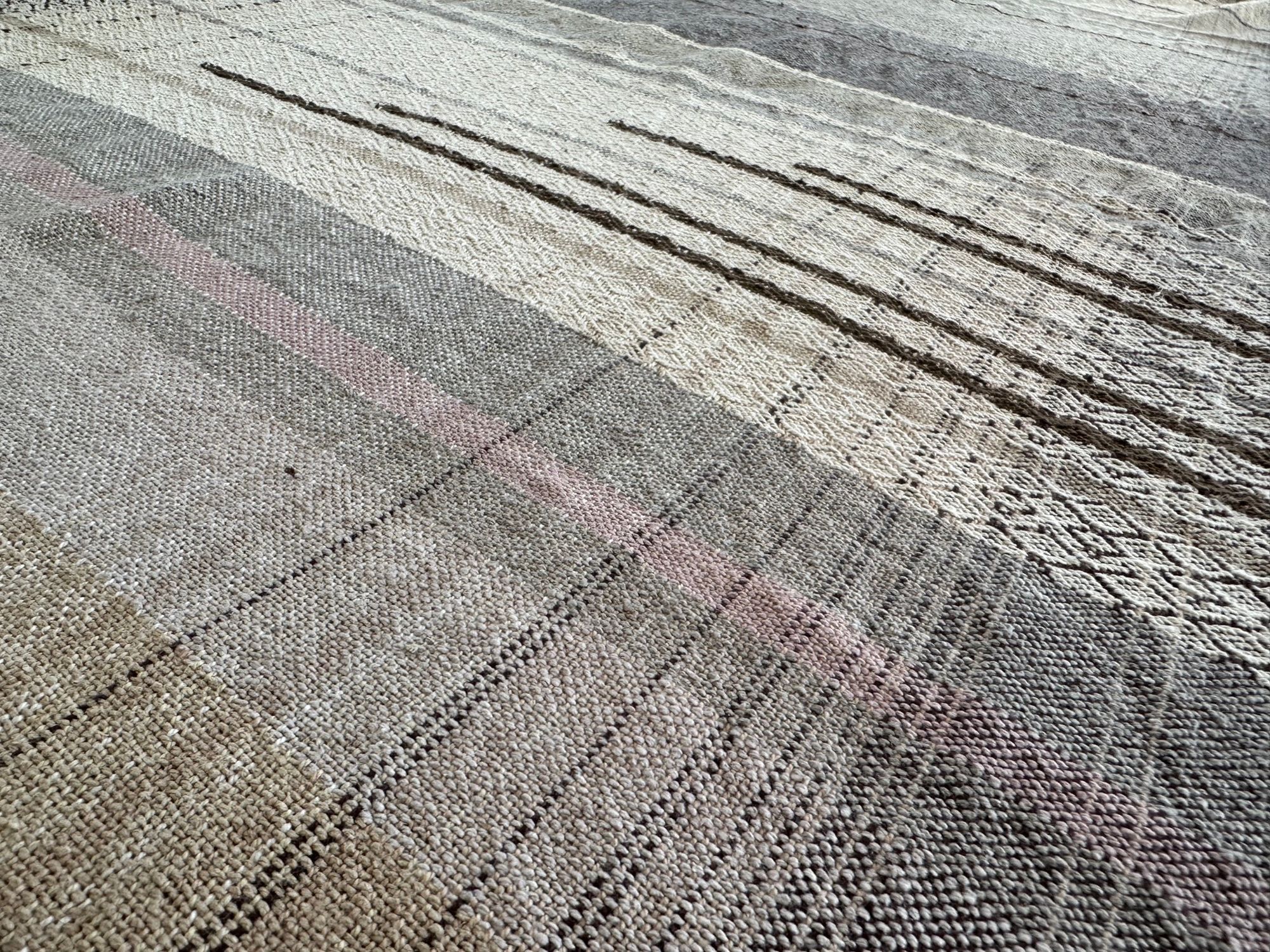 Details of a handwoven naturally dyed raw silken organic cotton linen shawl with diamond pattern and stripes of gradations of grey, brown, tan and white.