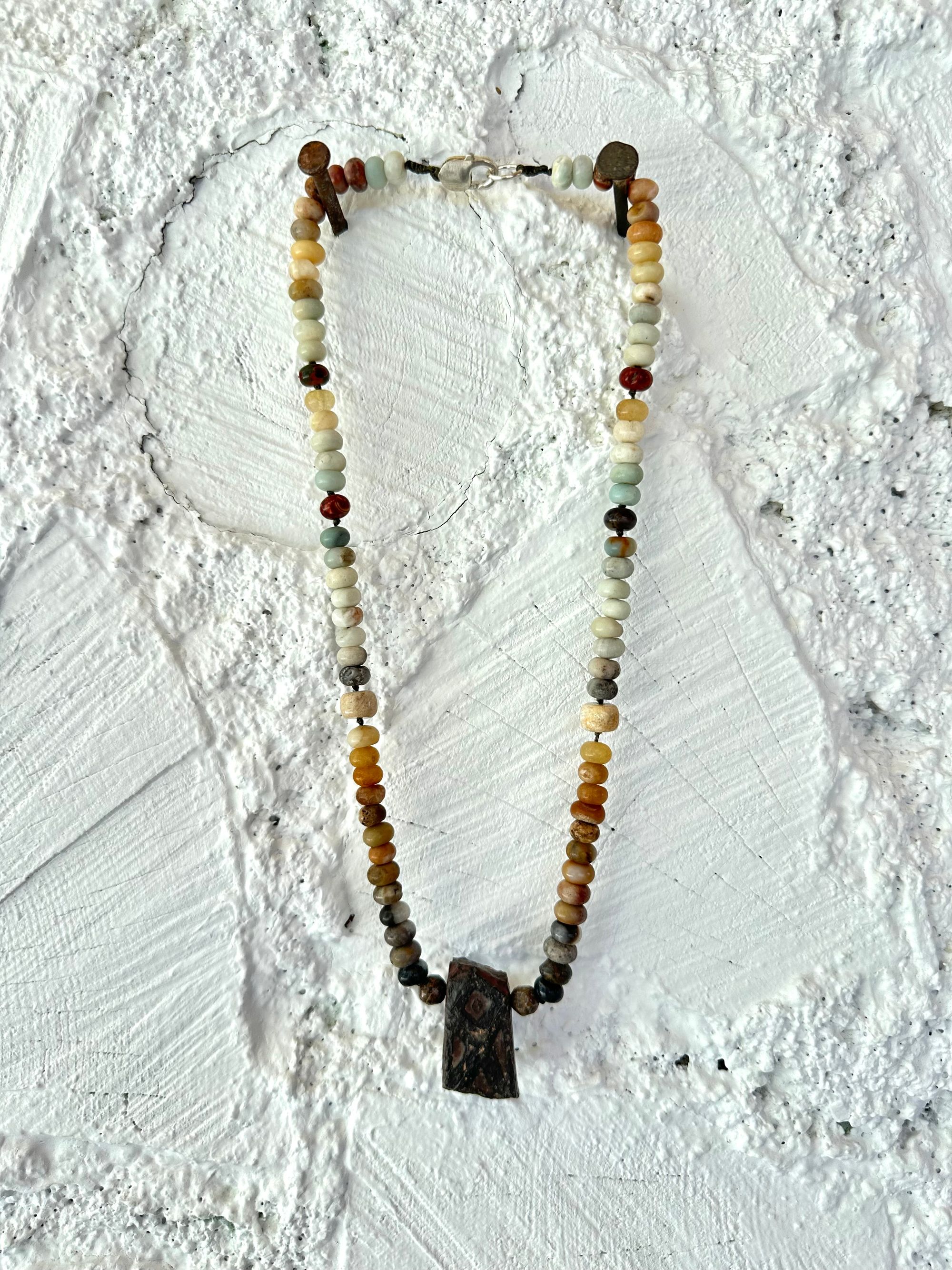 A necklace made of Gray, black and brown tsesit, A while, ancient stone is formed into an necklace with a rainbow of Jasper bees, petrified, dinosaur bone and fossilized coral