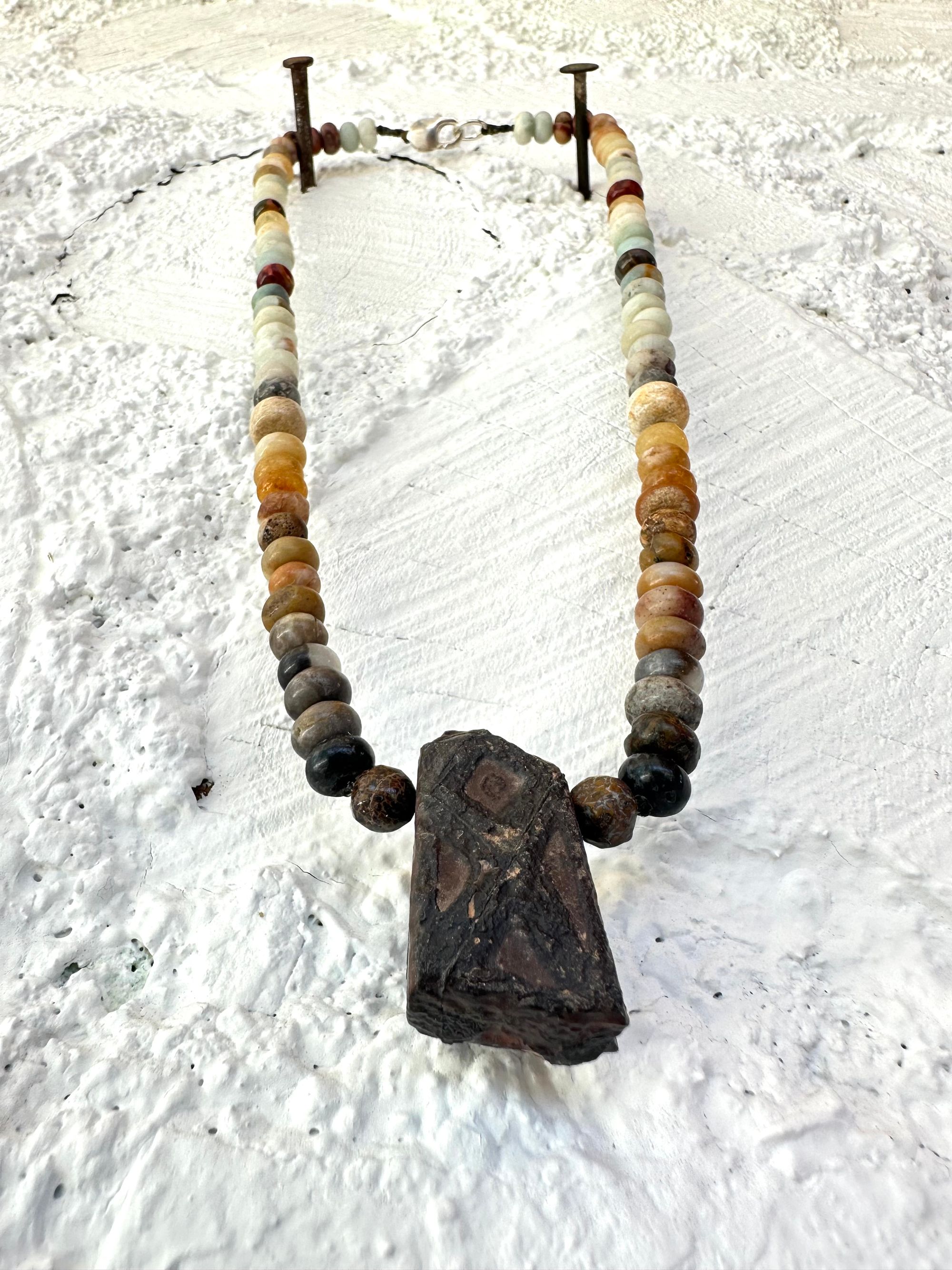 A necklace made of Gray, black and brown tsesit, A while, ancient stone is formed into an necklace with a rainbow of Jasper bees, petrified, dinosaur bone and fossilized coral