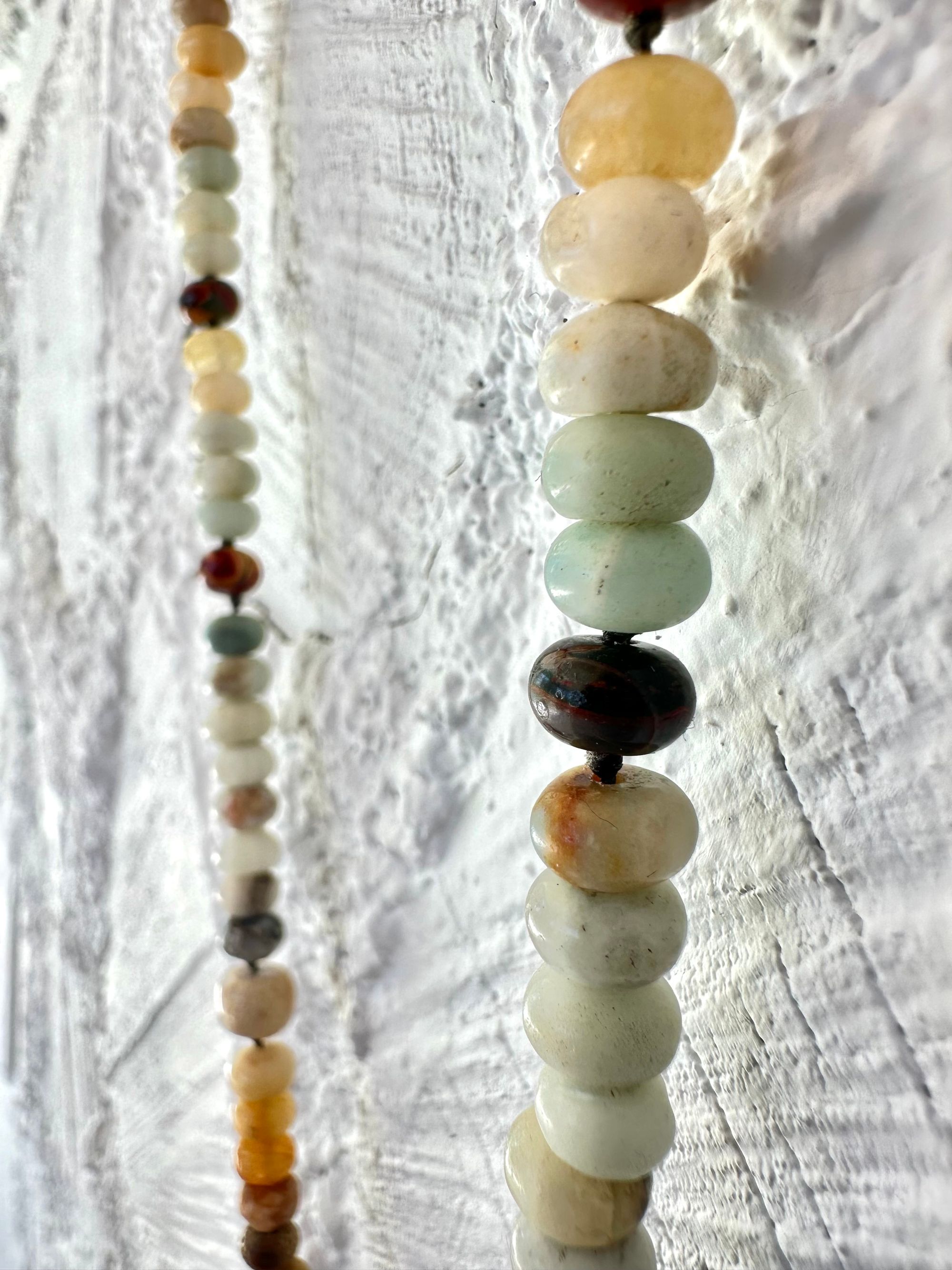 A necklace made of Gray, black and brown tsesit, A while, ancient stone is formed into an necklace with a rainbow of Jasper bees, petrified, dinosaur bone and fossilized coral