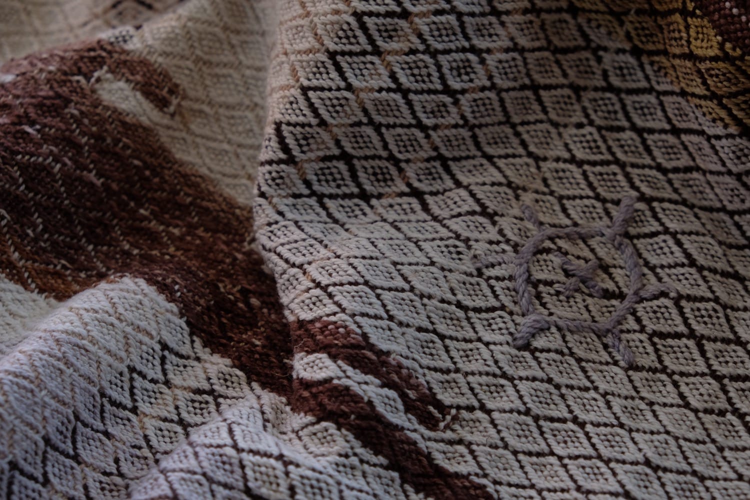 A length of handwoven fabric with details of fluid rainbows, a blue illuminated river and snowflakes