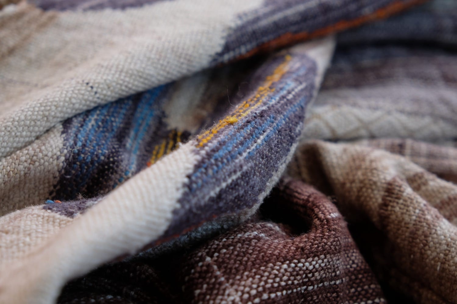 A length of handwoven fabric with details of fluid rainbows, a blue illuminated river and snowflakes