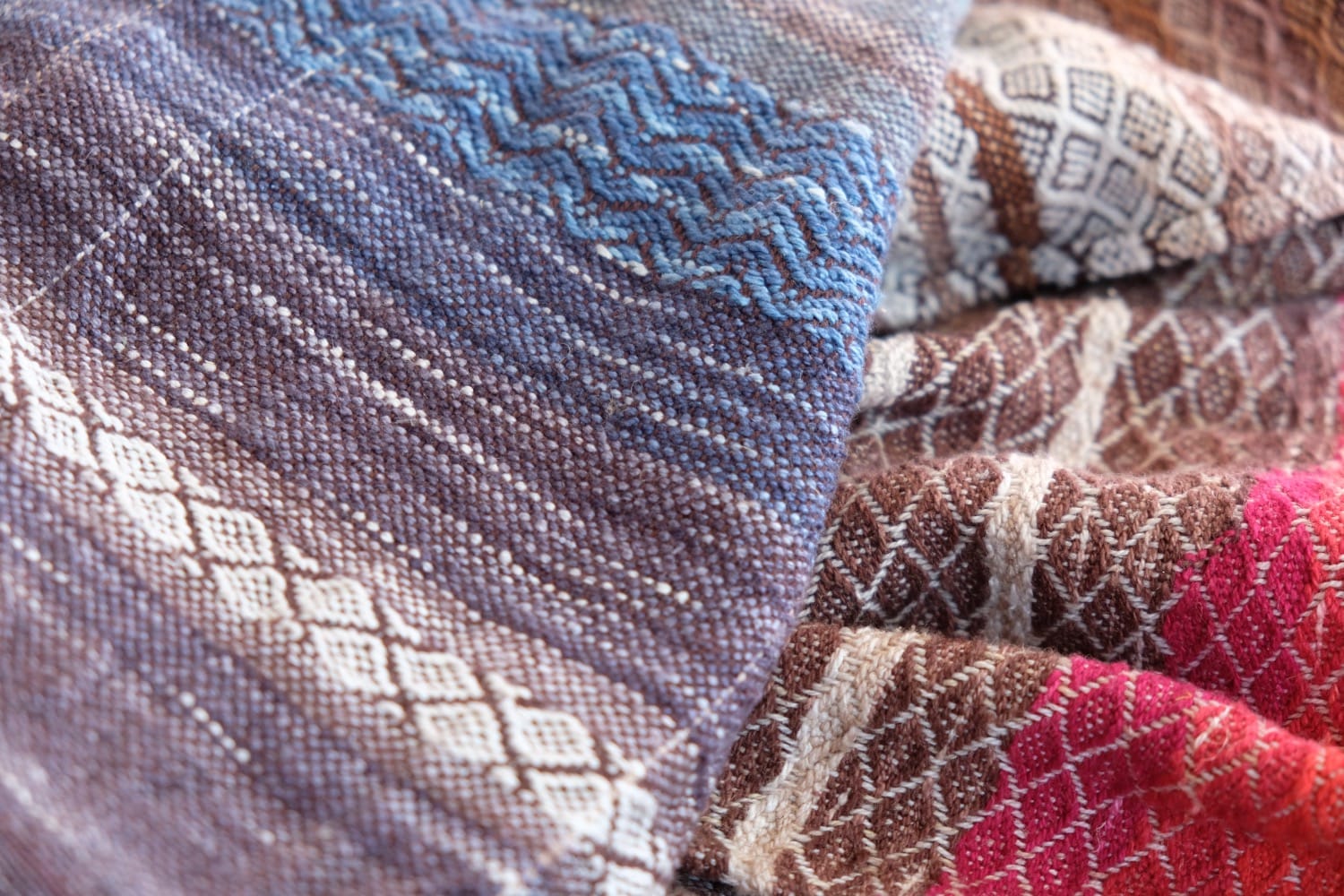 A length of handwoven fabric with details of fluid rainbows, a blue illuminated river and snowflakes